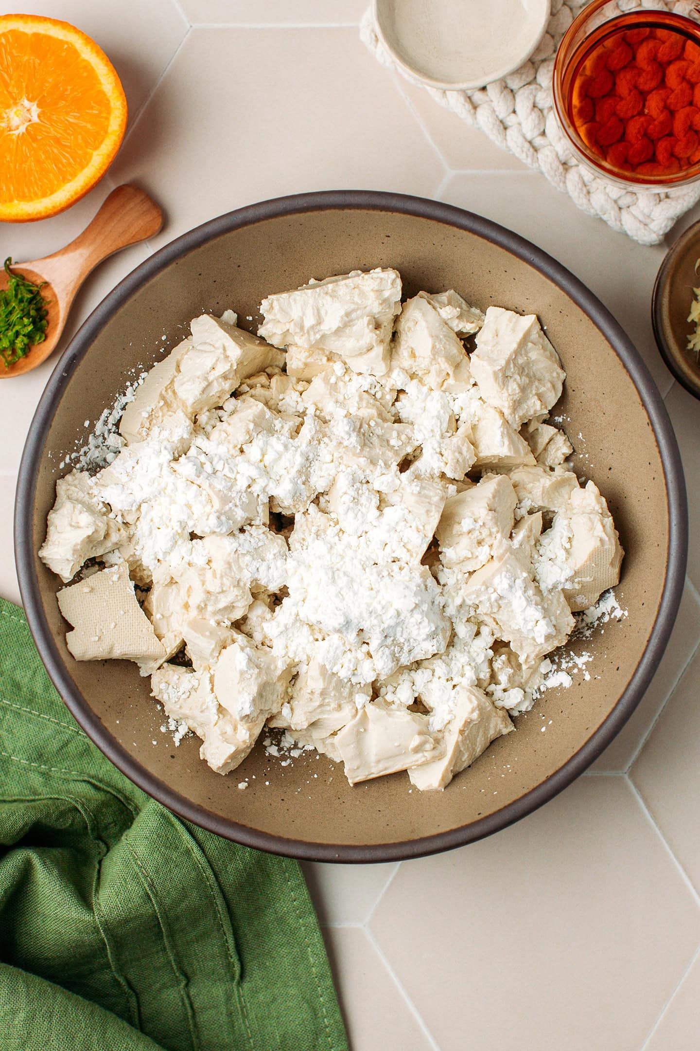 Crumbled tofu in a bowl with cornstarch.