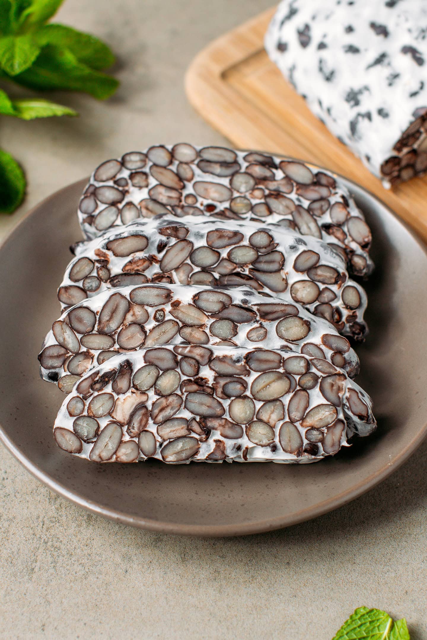 Four slices of black bean tempeh on a small brown plate.