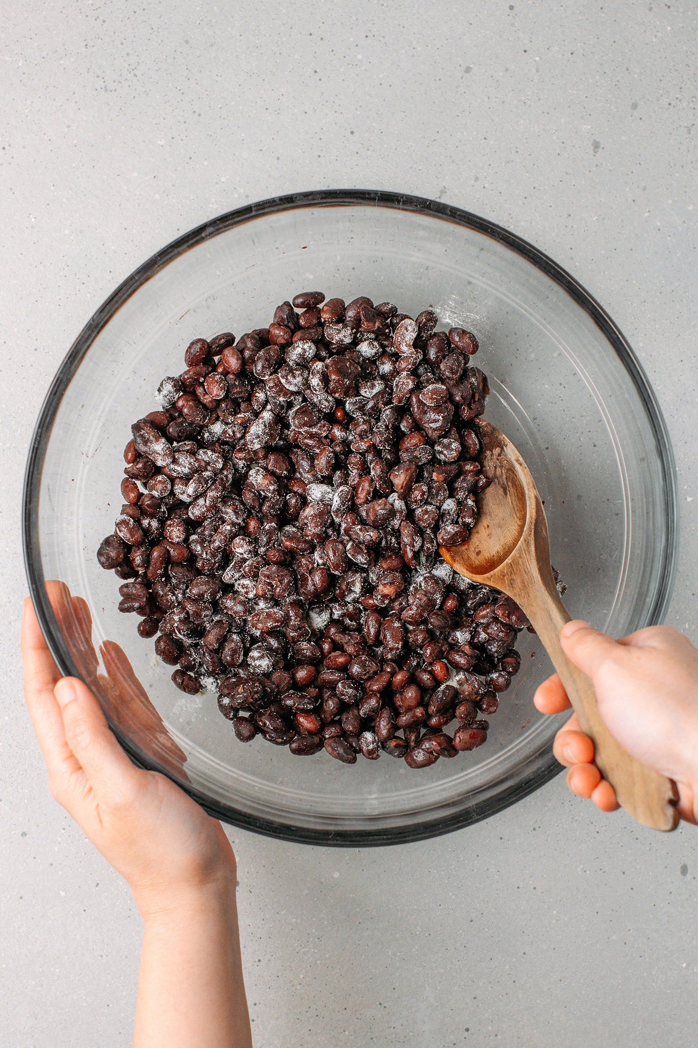Mixing cooked black beans with vinegar and tempeh starter.