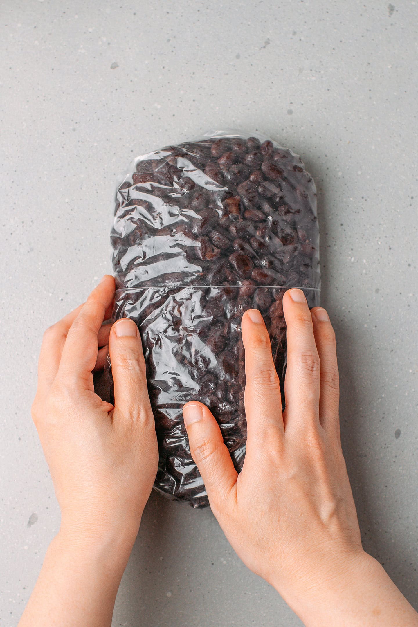 Packing black beans tight into a freezer bag.