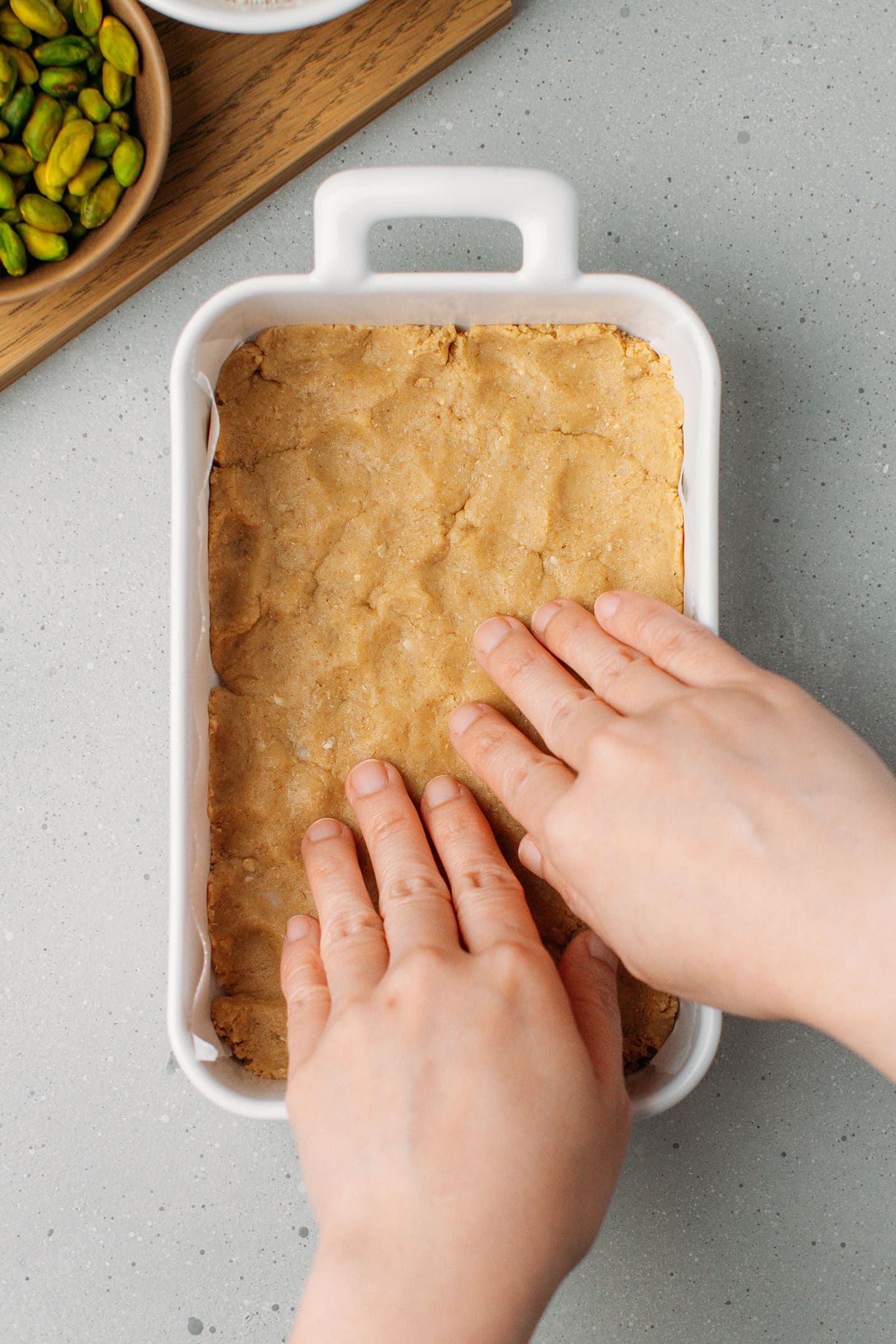 Pressing shortbread crust into a baking dish.
