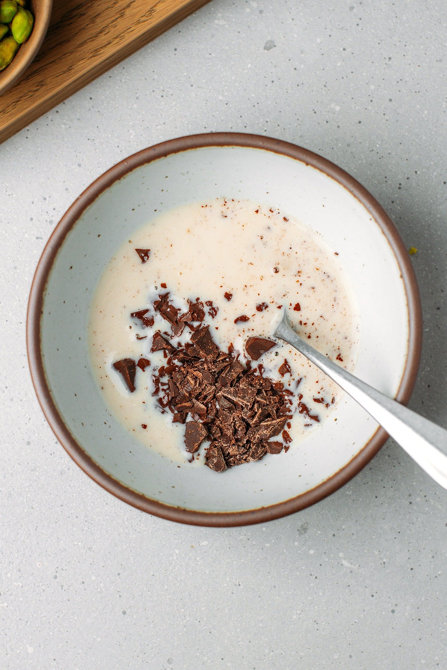 Hot milk and chopped dark chocolate in a bowl.