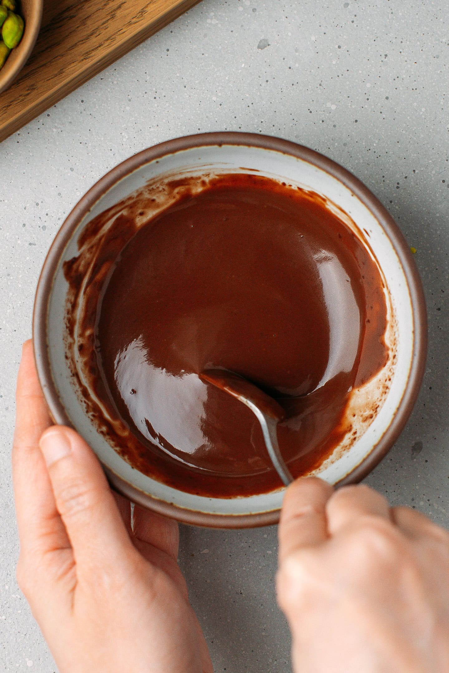 Stirring chocolate ganache in a small bowl.