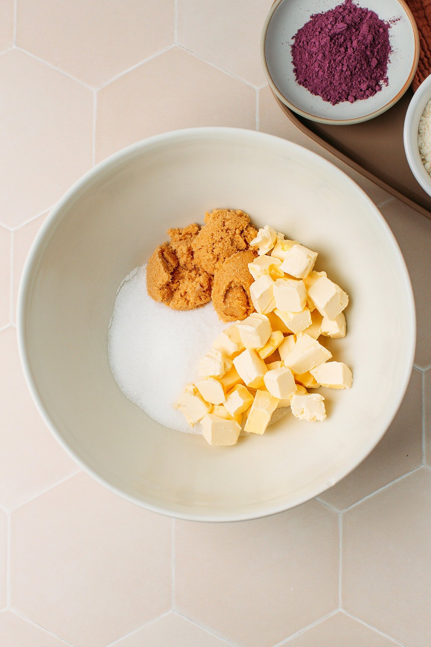 White sugar, light brown sugar, and diced butter in a mixing bowl.