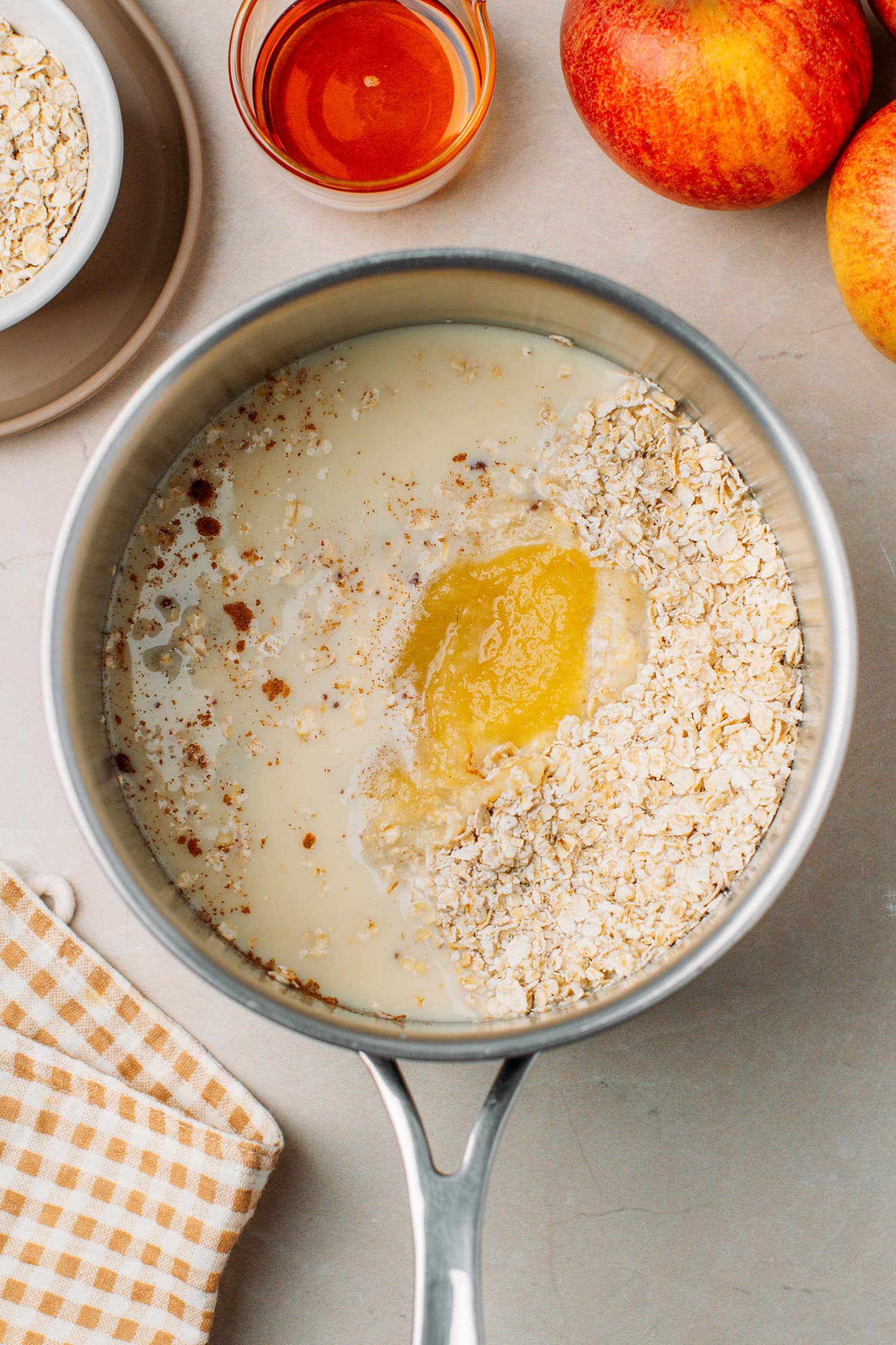 Oats, applesauce, milk, and cinnamon in a saucepan.