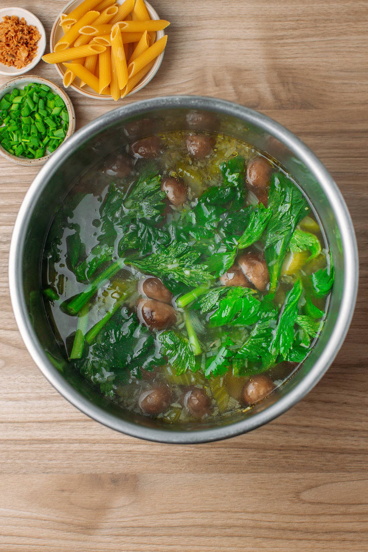 Celery soup with mushrooms, potatoes, and carrots in a pot.