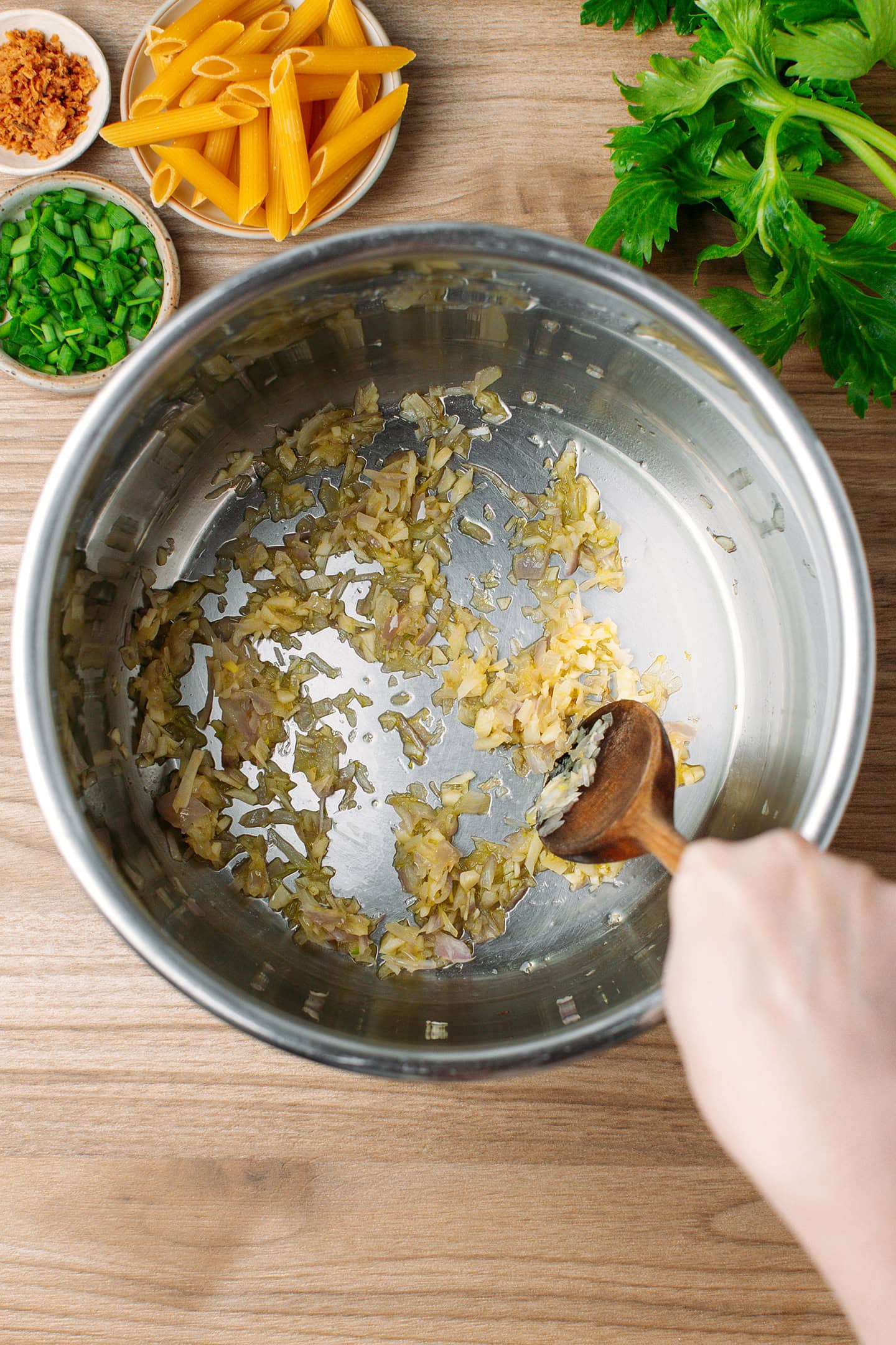 Stirring saut&eacute;ed garlic and shallots in a pot.