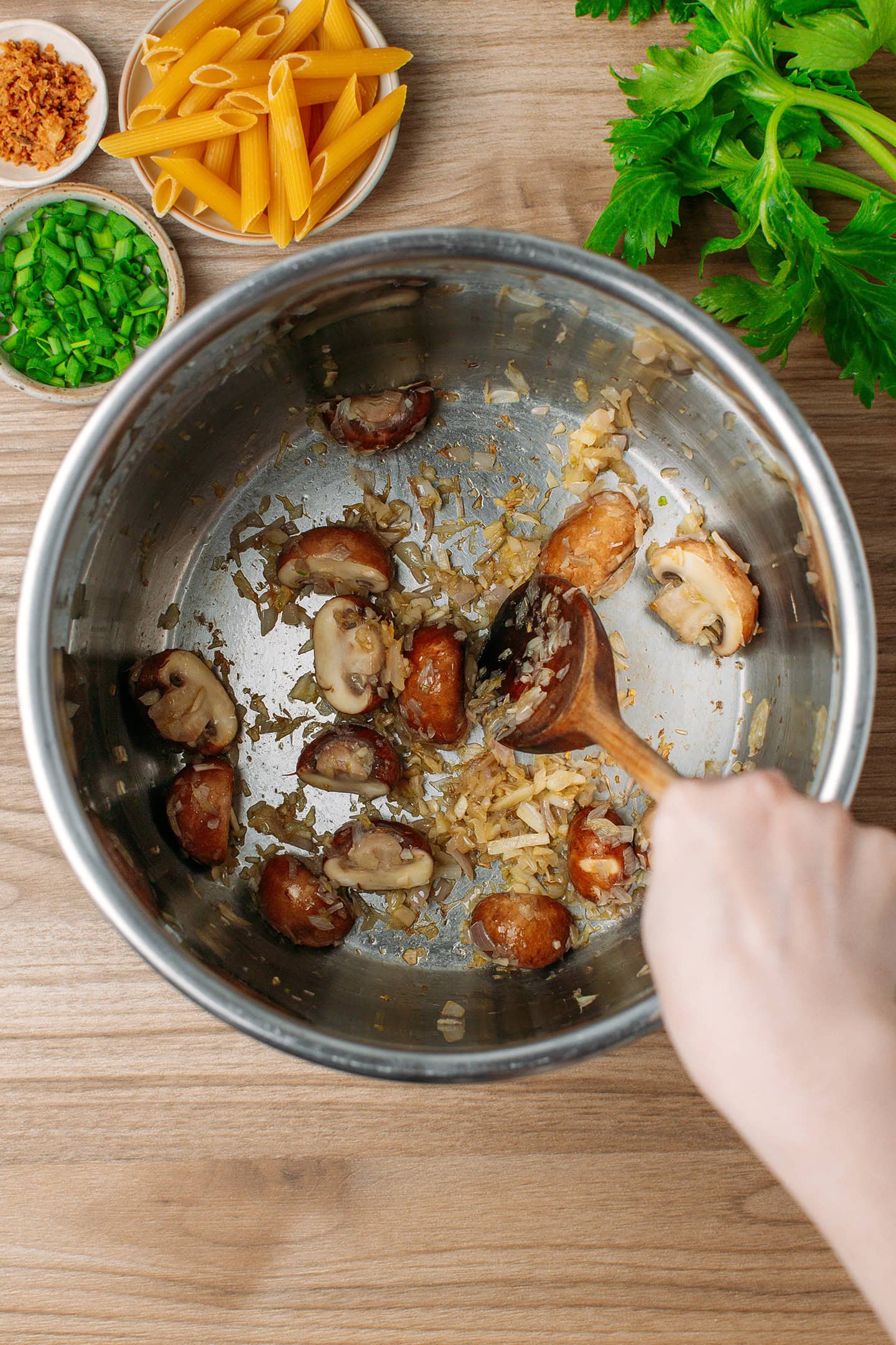 Saut&eacute;eing sliced mushrooms in a pot.