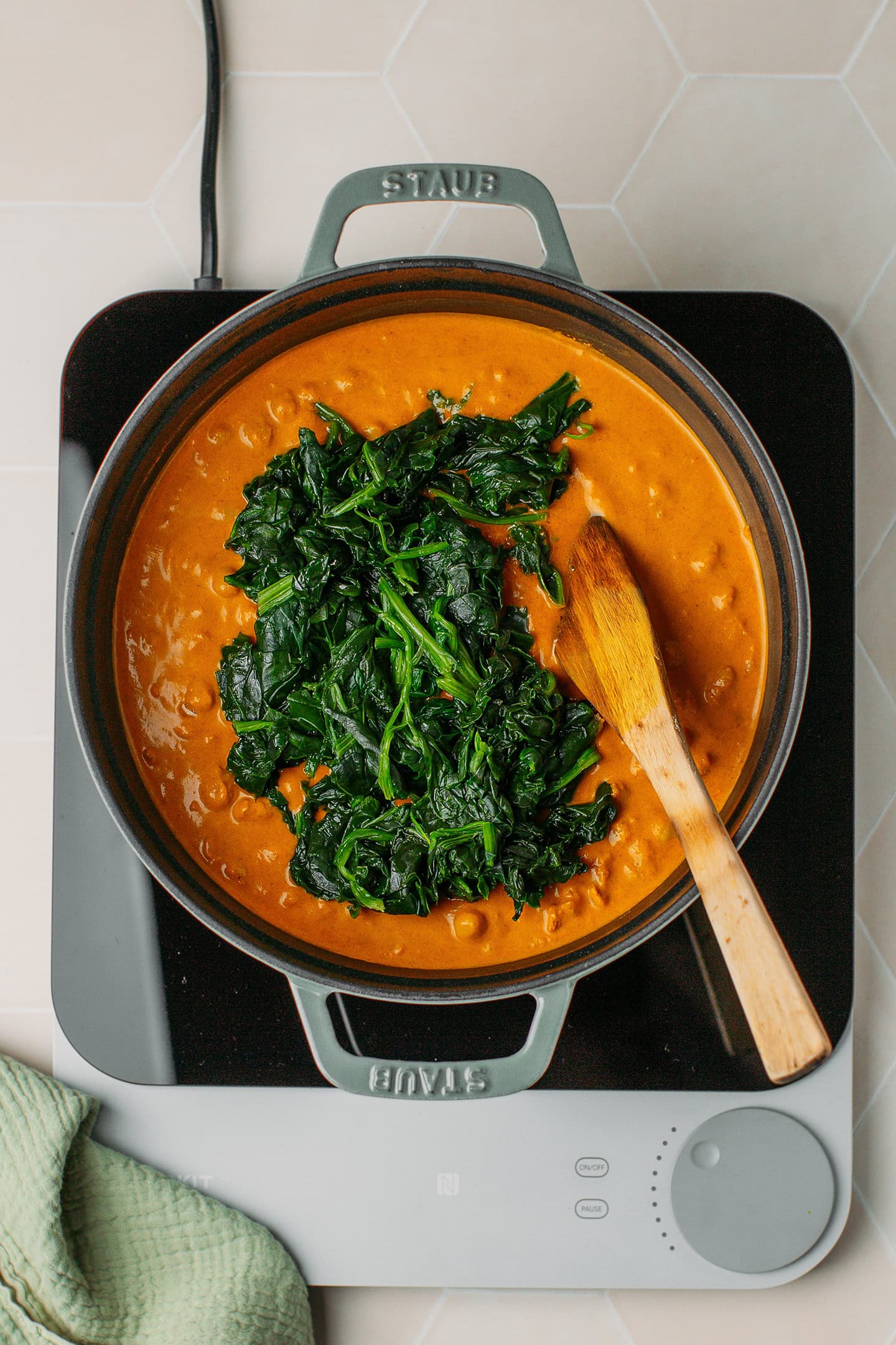 Chickpea curry and frozen spinach in a Dutch oven.