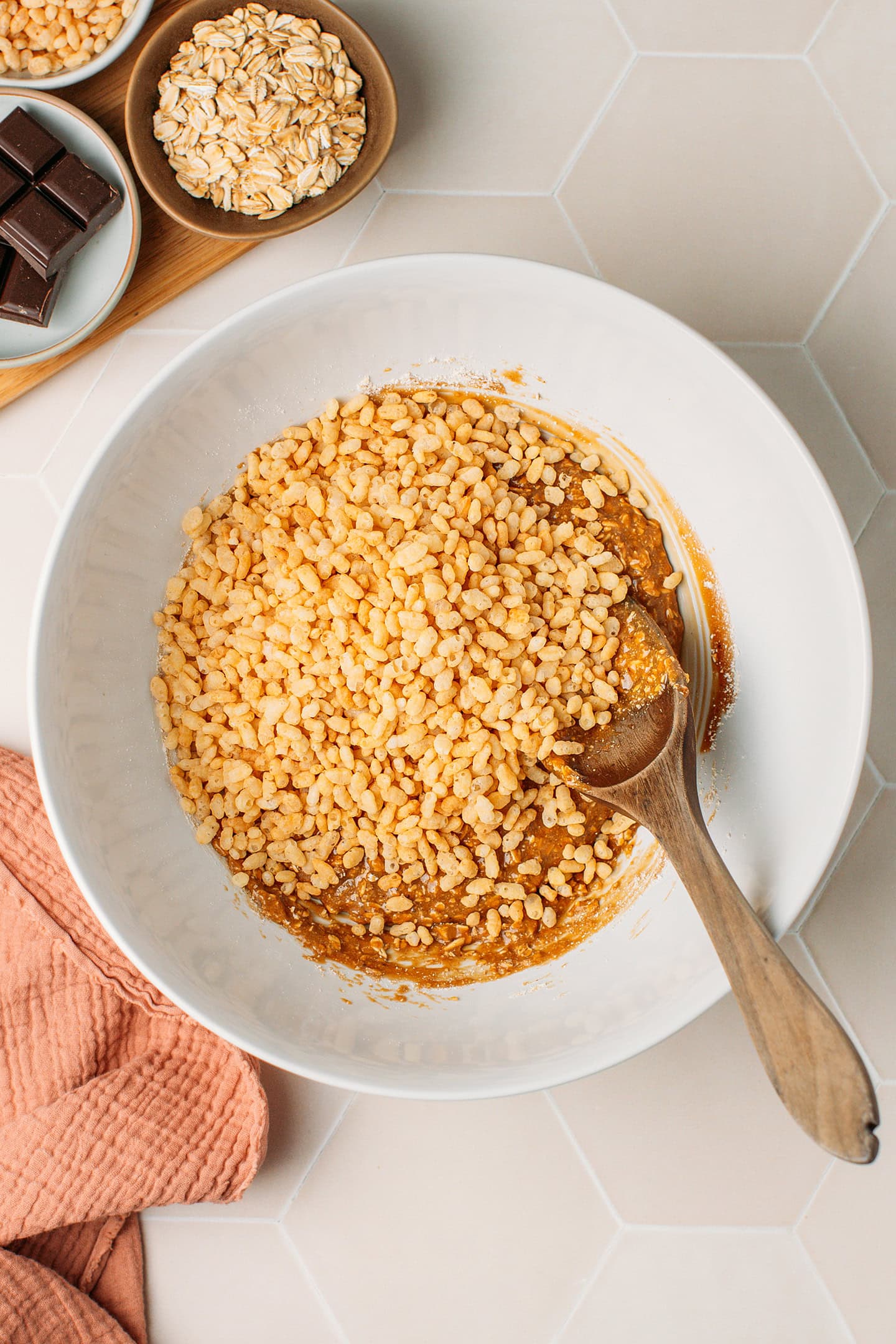 Sticky oat mixture and rice crisps in a mixing bowl.