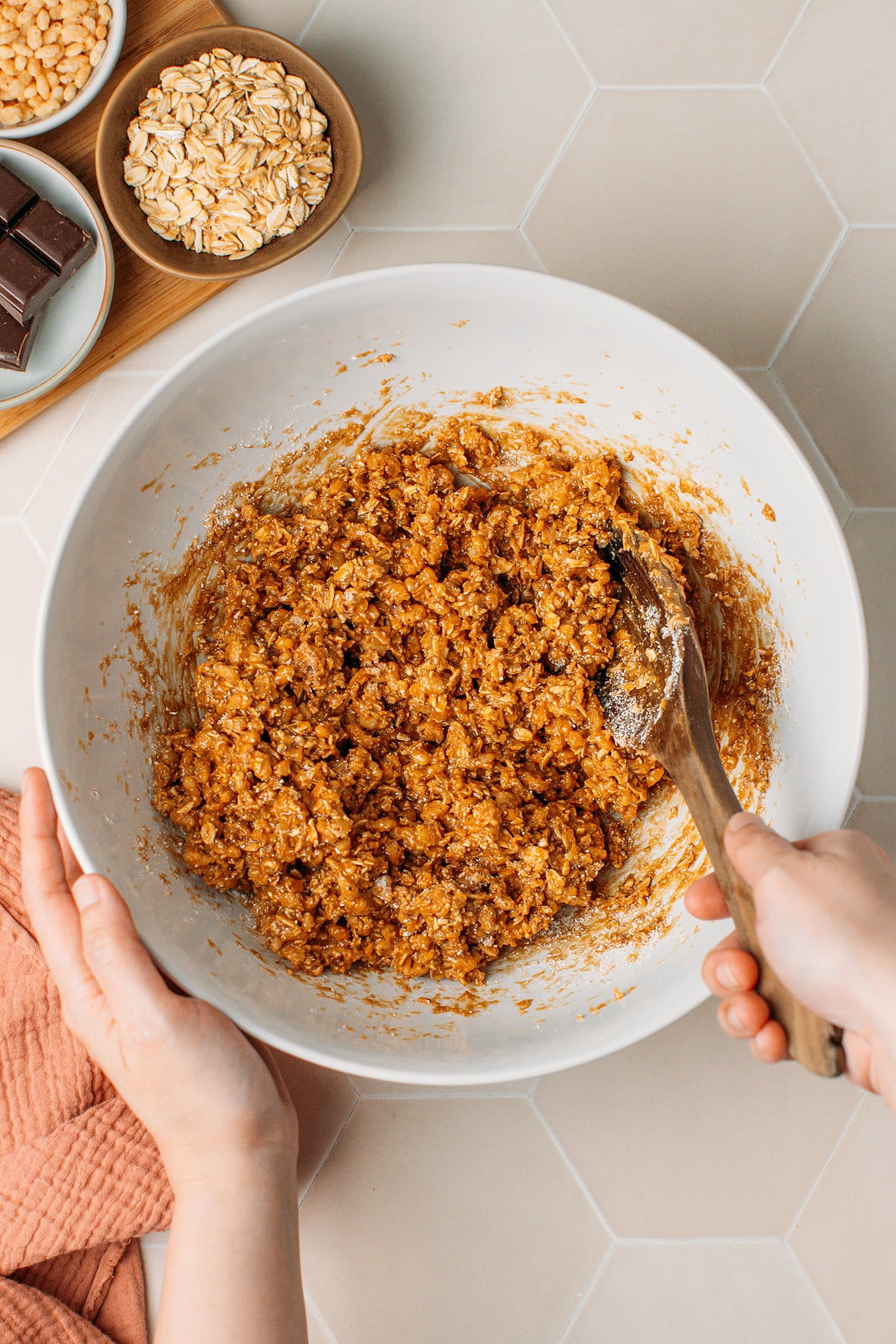 Folding rice crisps into a sticky oat mixture.