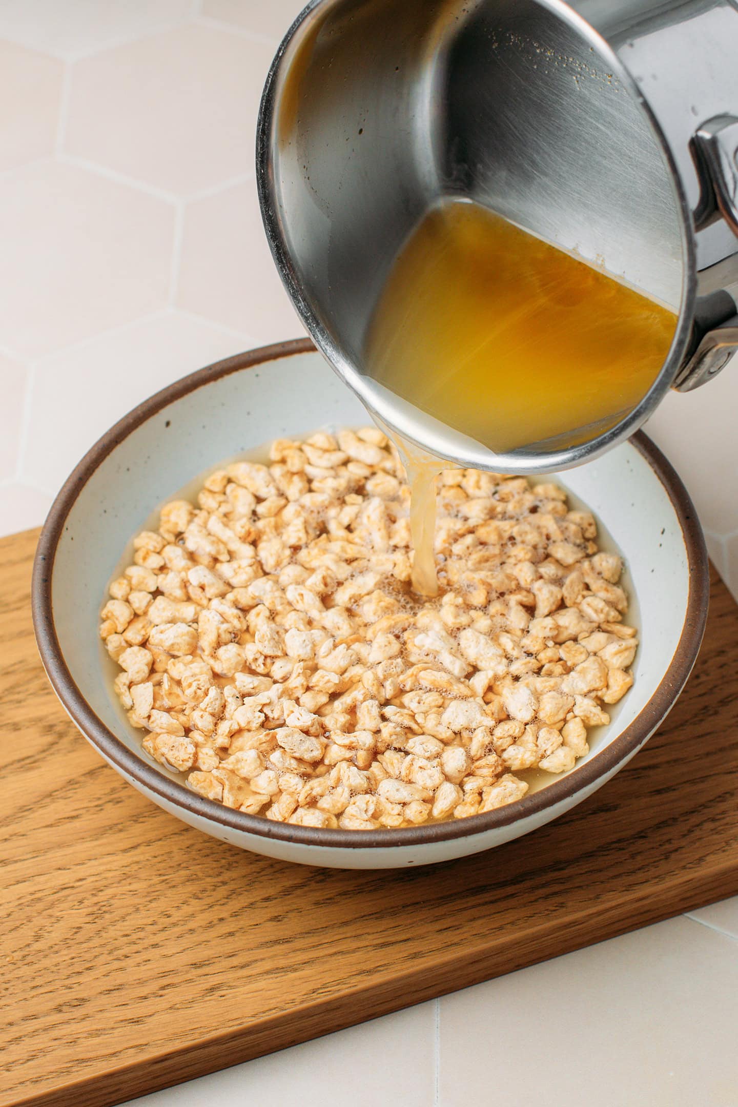 Pouring vegetable broth over textured vegetable protein.