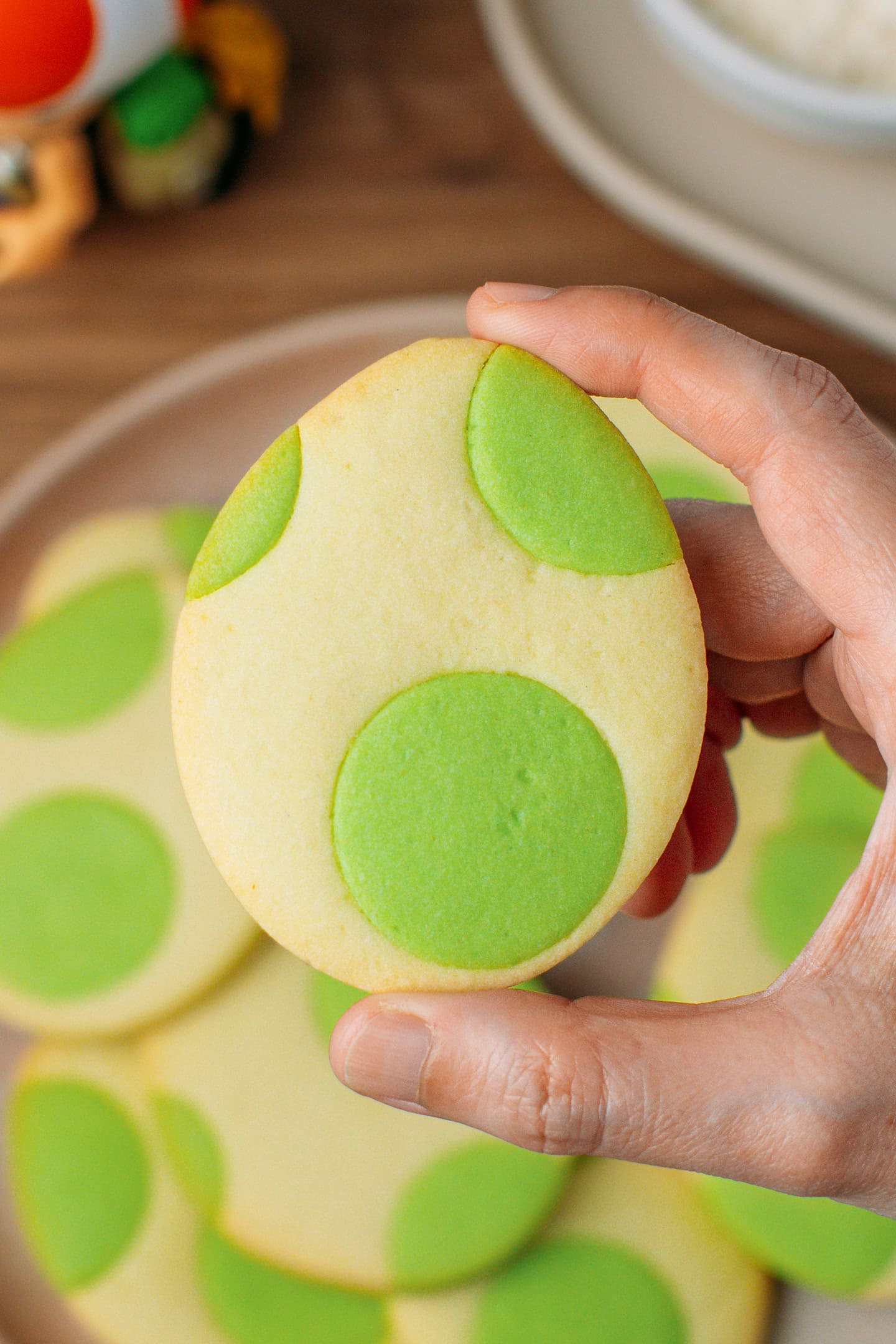Holding a cookie in the shape of Yoshi's eggs.
