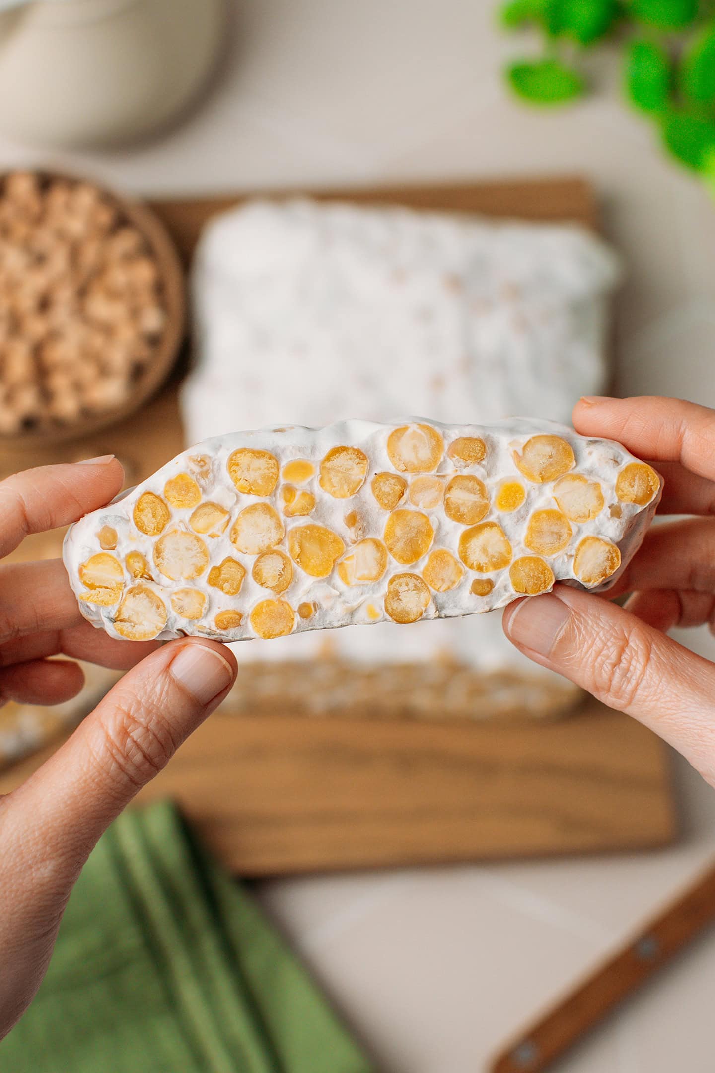 Holding a slice of chickpea tempeh.