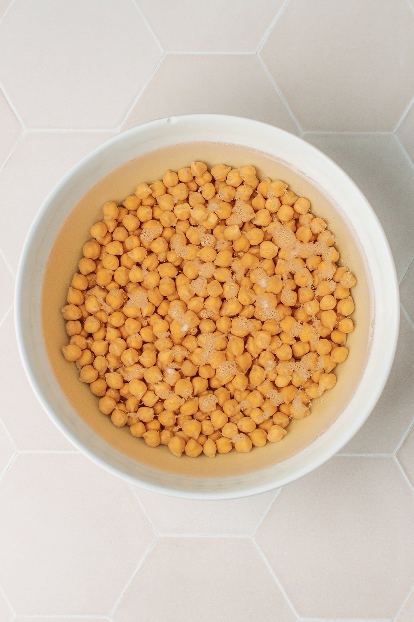Soaked chickpeas in a large bowl.