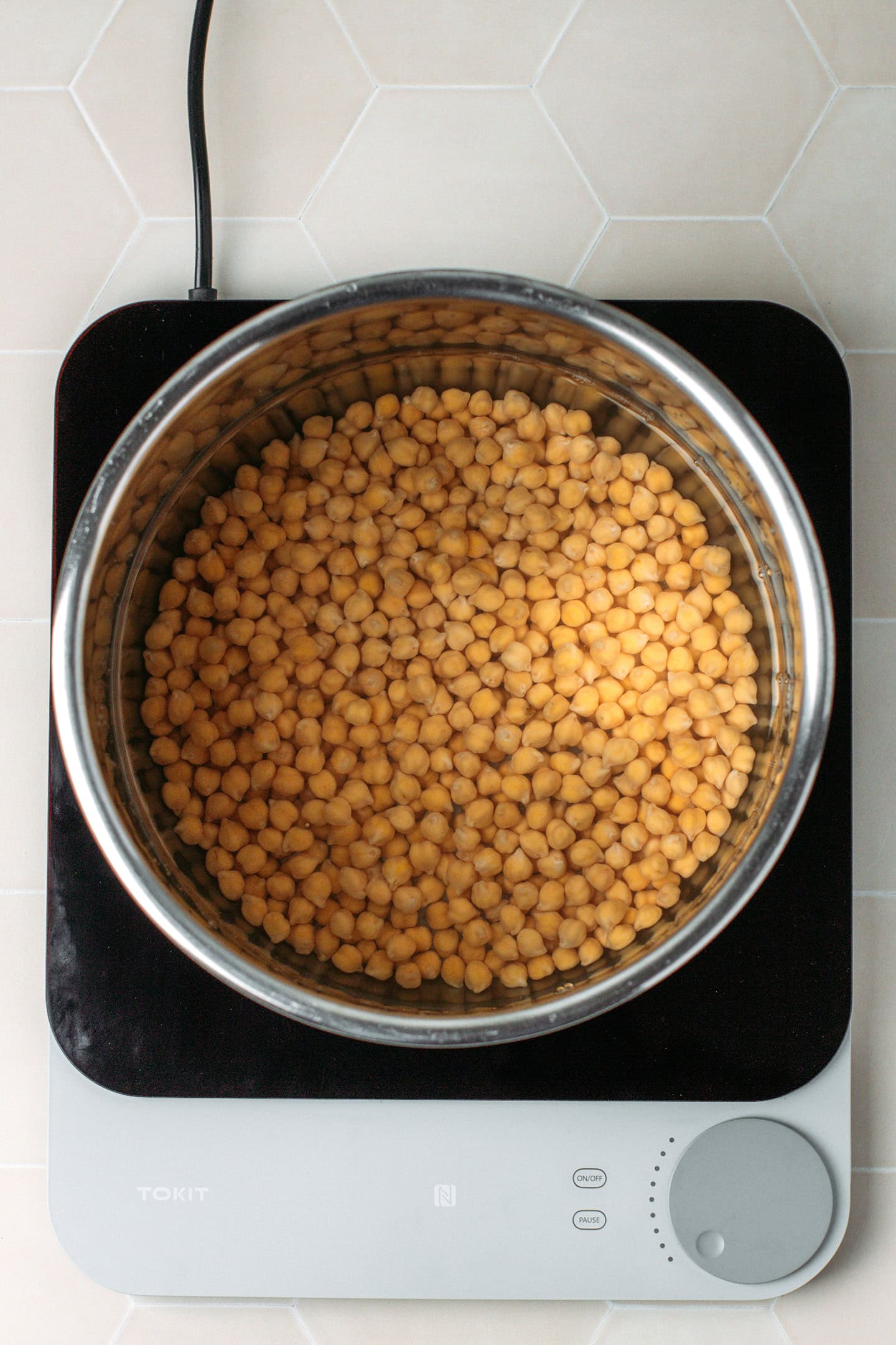 Uncooked chickpeas and water in a pot.