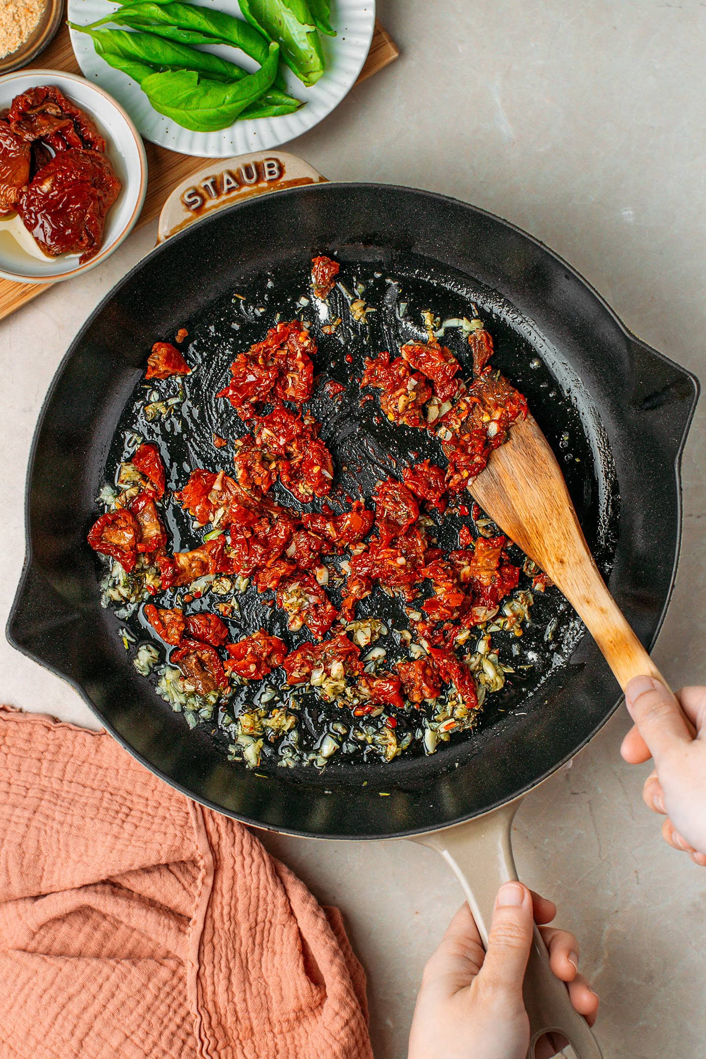 Saut&eacute;ed garlic and chopped sun-dried tomatoes in a skillet.