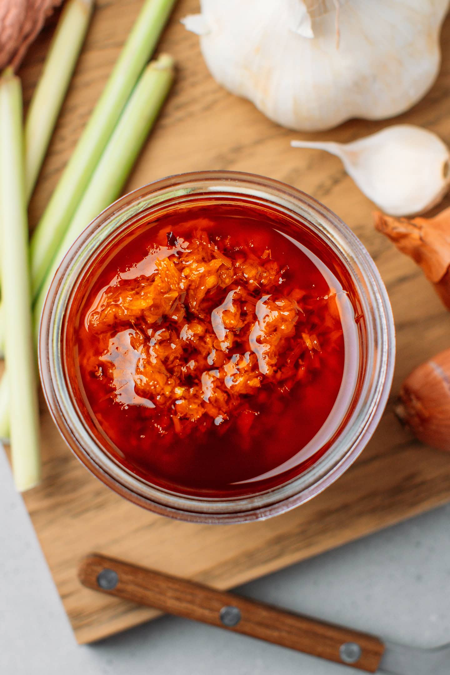 Top view of a jar of sate on a wooden board.