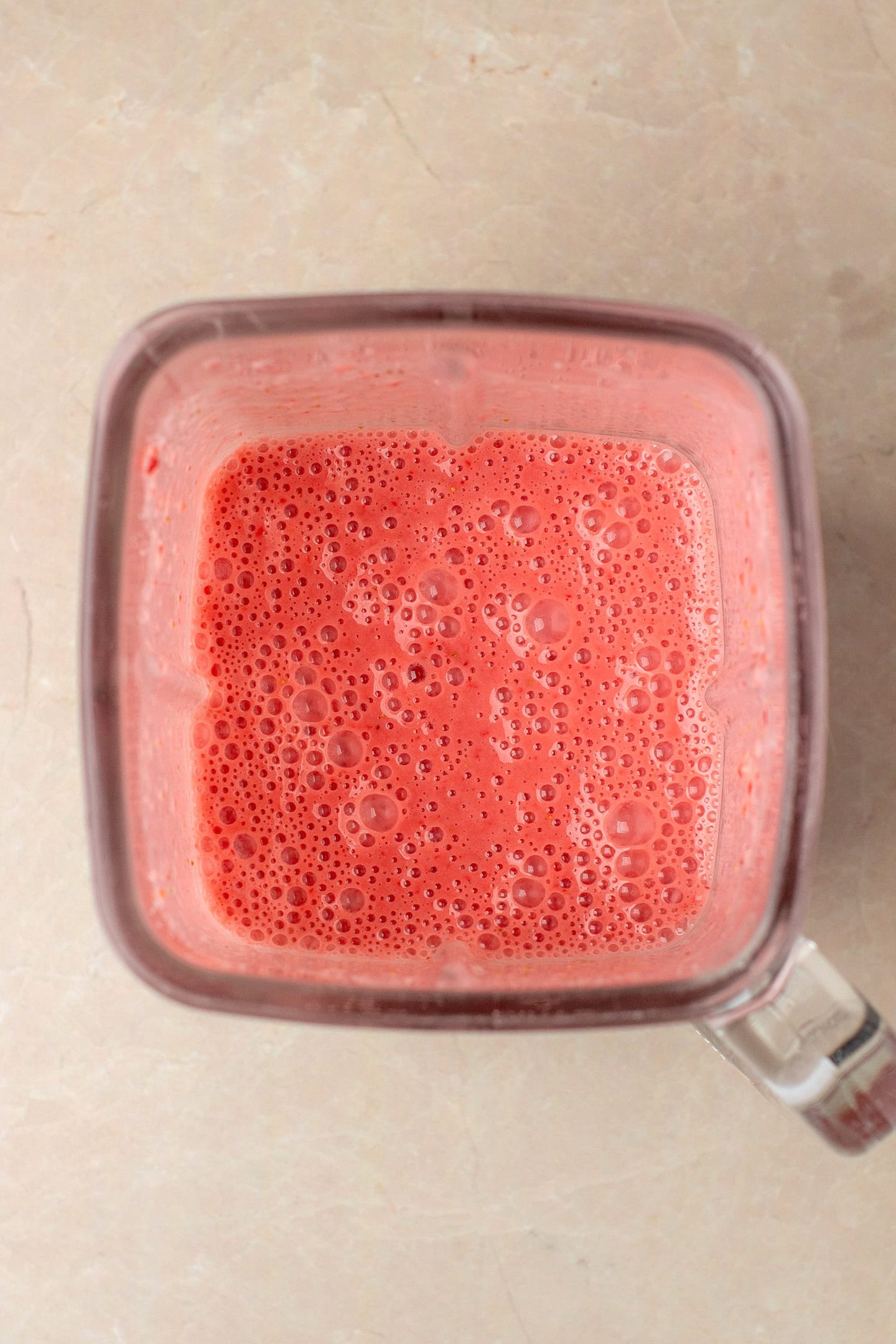 Blended strawberries and coconut milk in a blender.