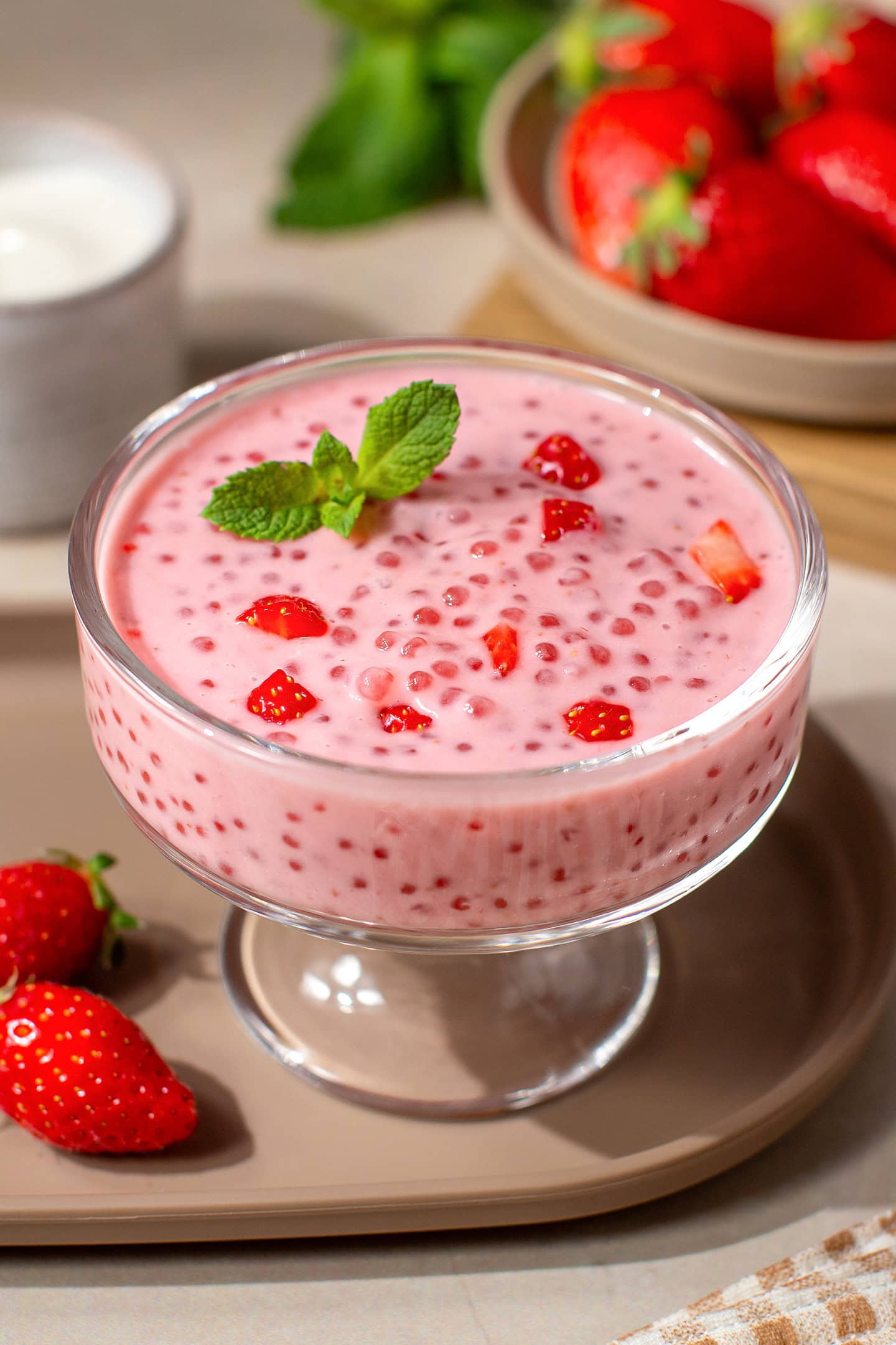 Strawberry sago with strawberry chunks in a glass ramekin.