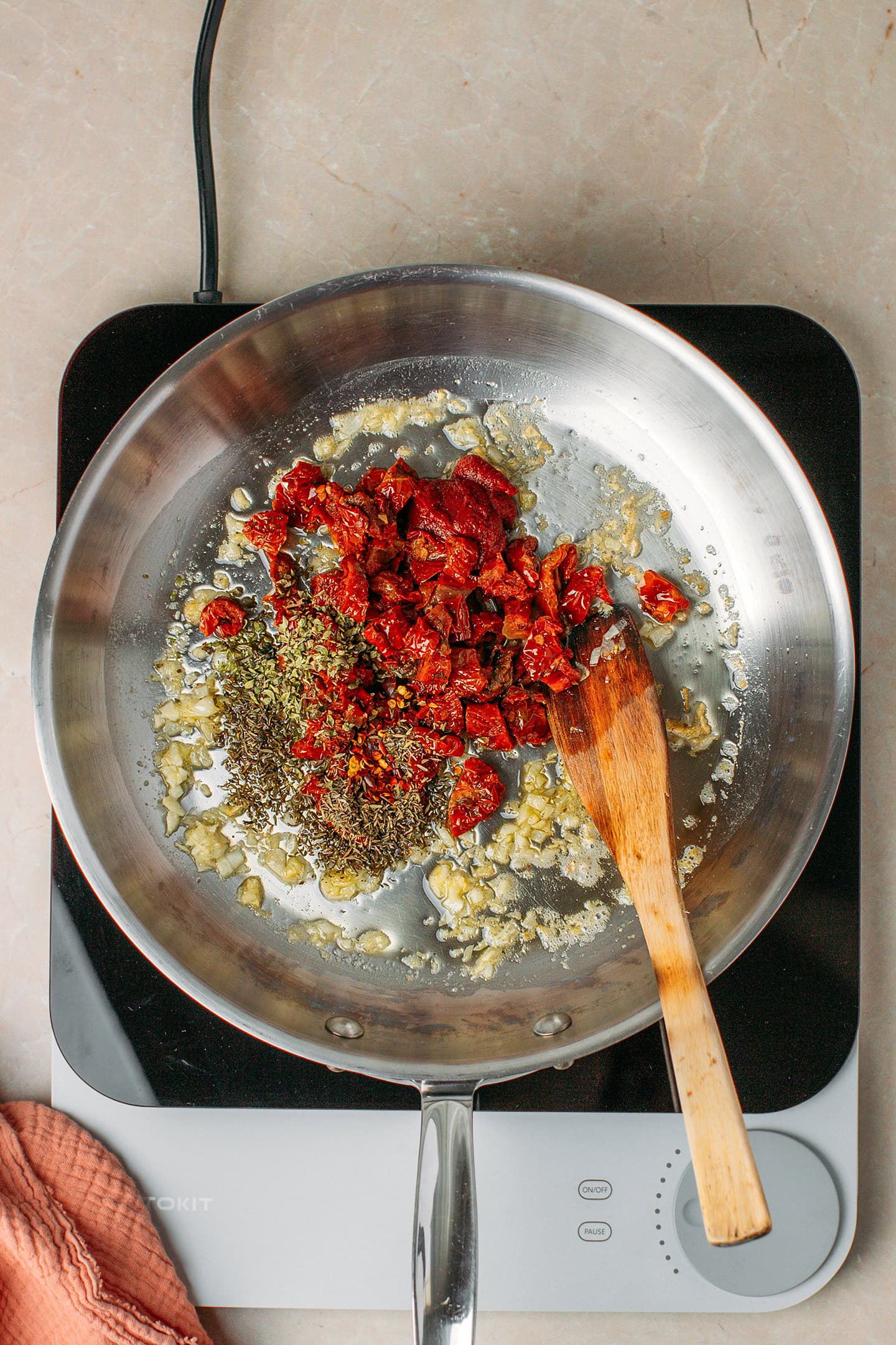 Saut&eacute;ed garlic, chopped sun-dried tomatoes, and dried herbs in a skillet.