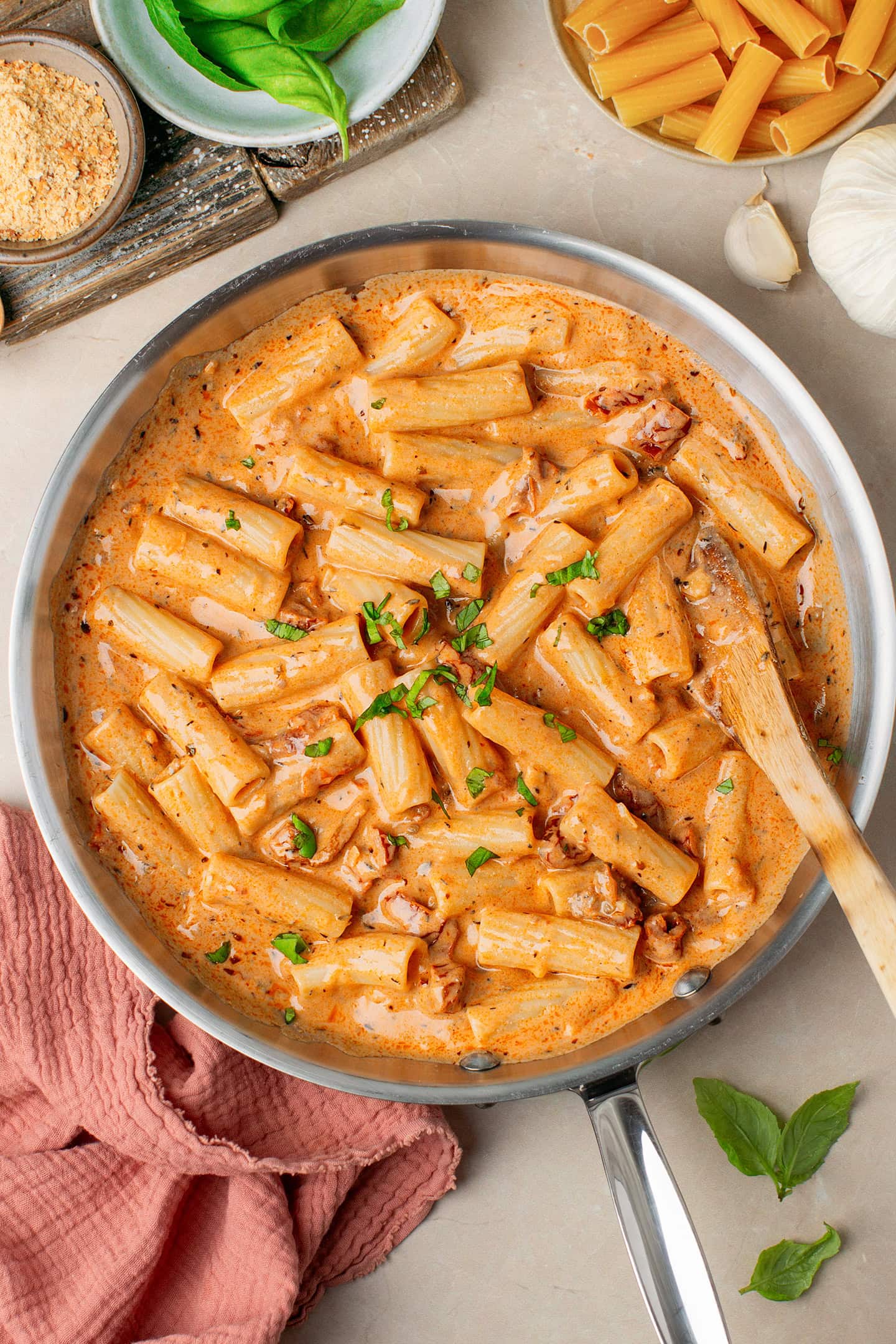 Pasta coated with a creamy sun-dried tomato sauce in a skillet.