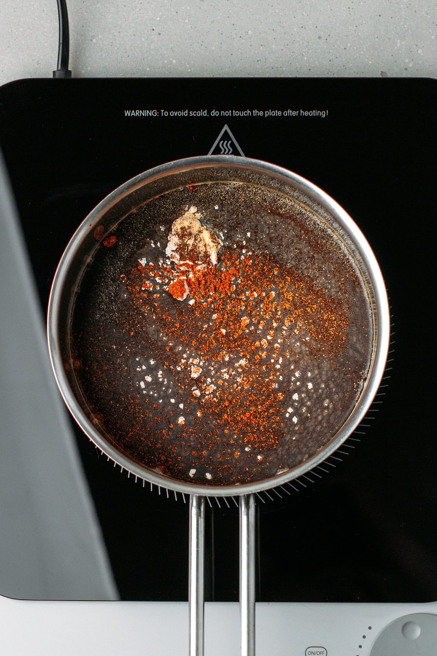 Apple cider vinegar, tamarind juice, and spices in a saucepan.