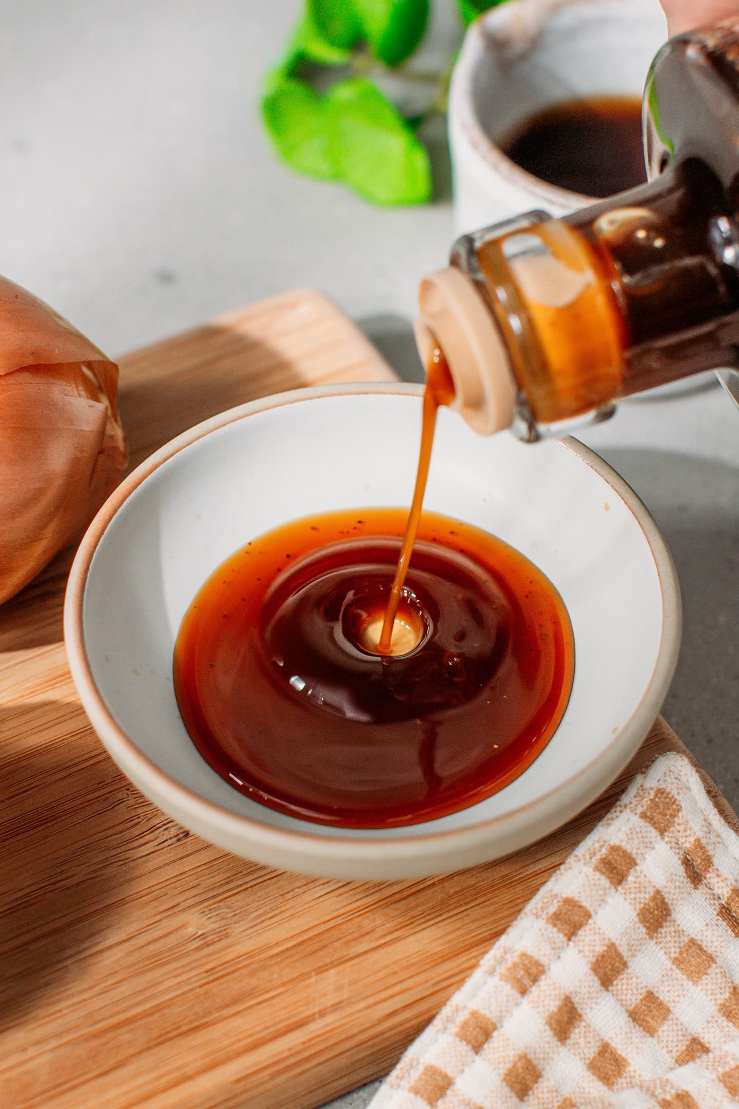 Pouring homemade Worcestershire sauce into a small bowl.