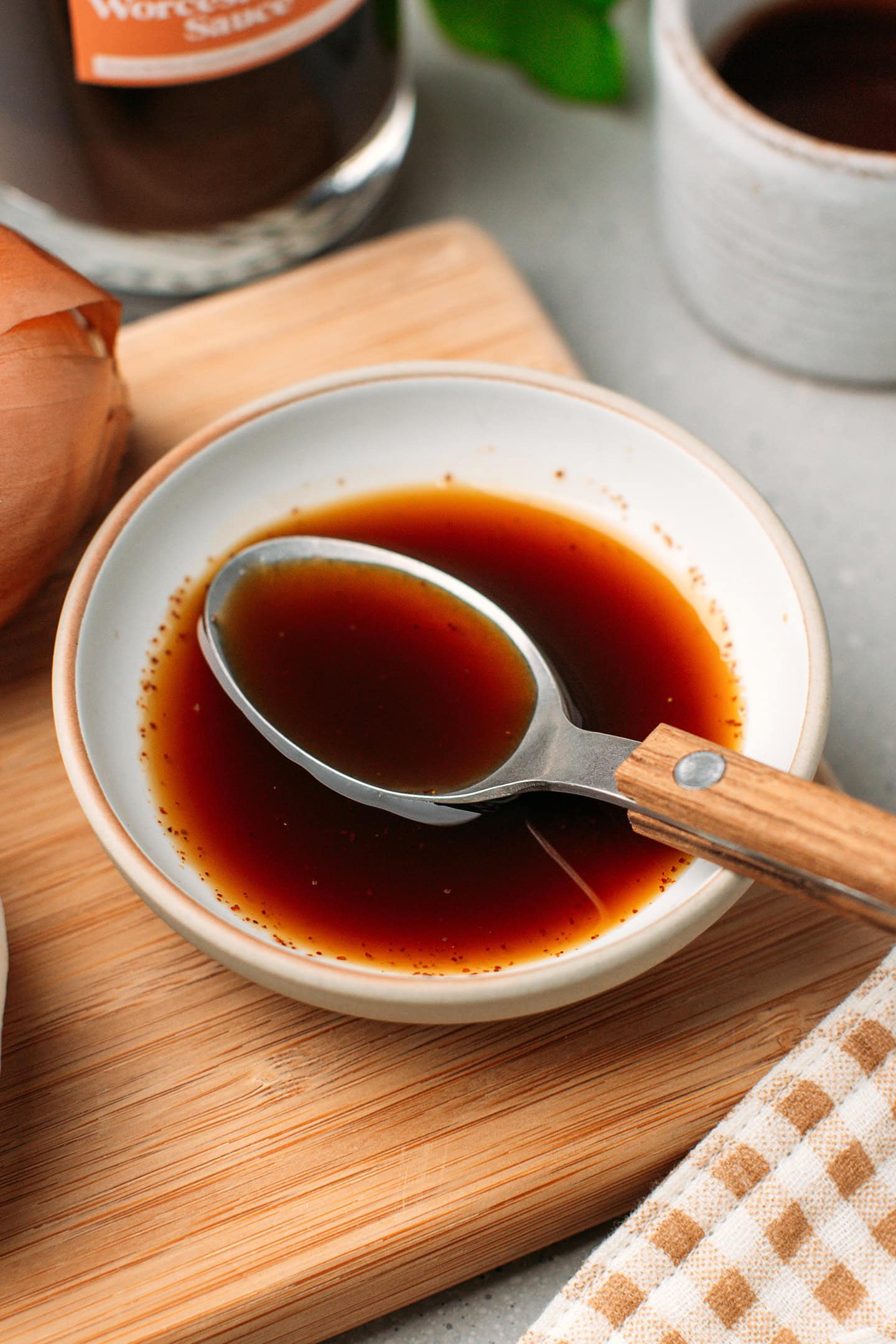 Spoonful of Worcestershire sauce sitting in a small bowl.