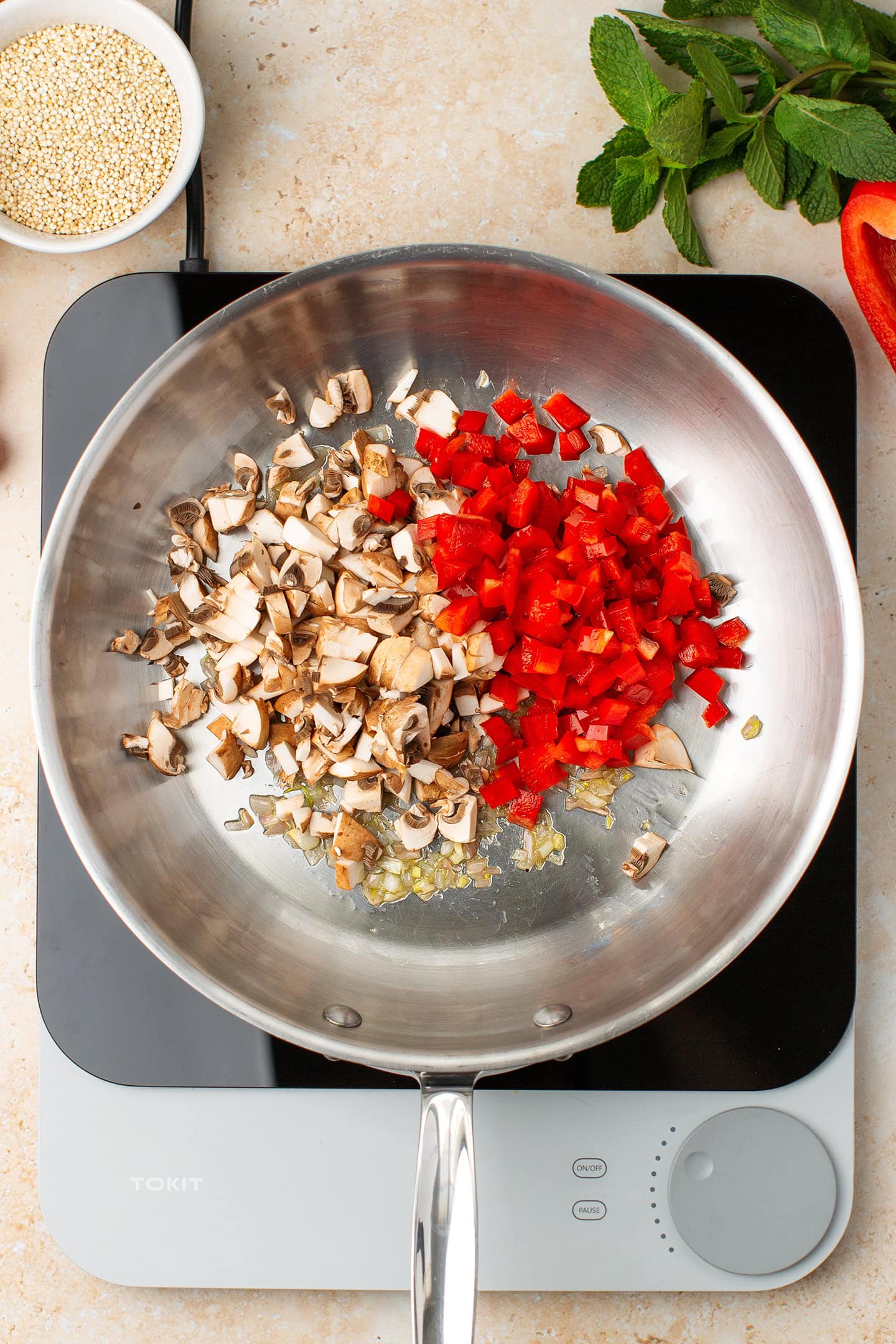 Diced mushrooms and red bell peppers in a skillet.