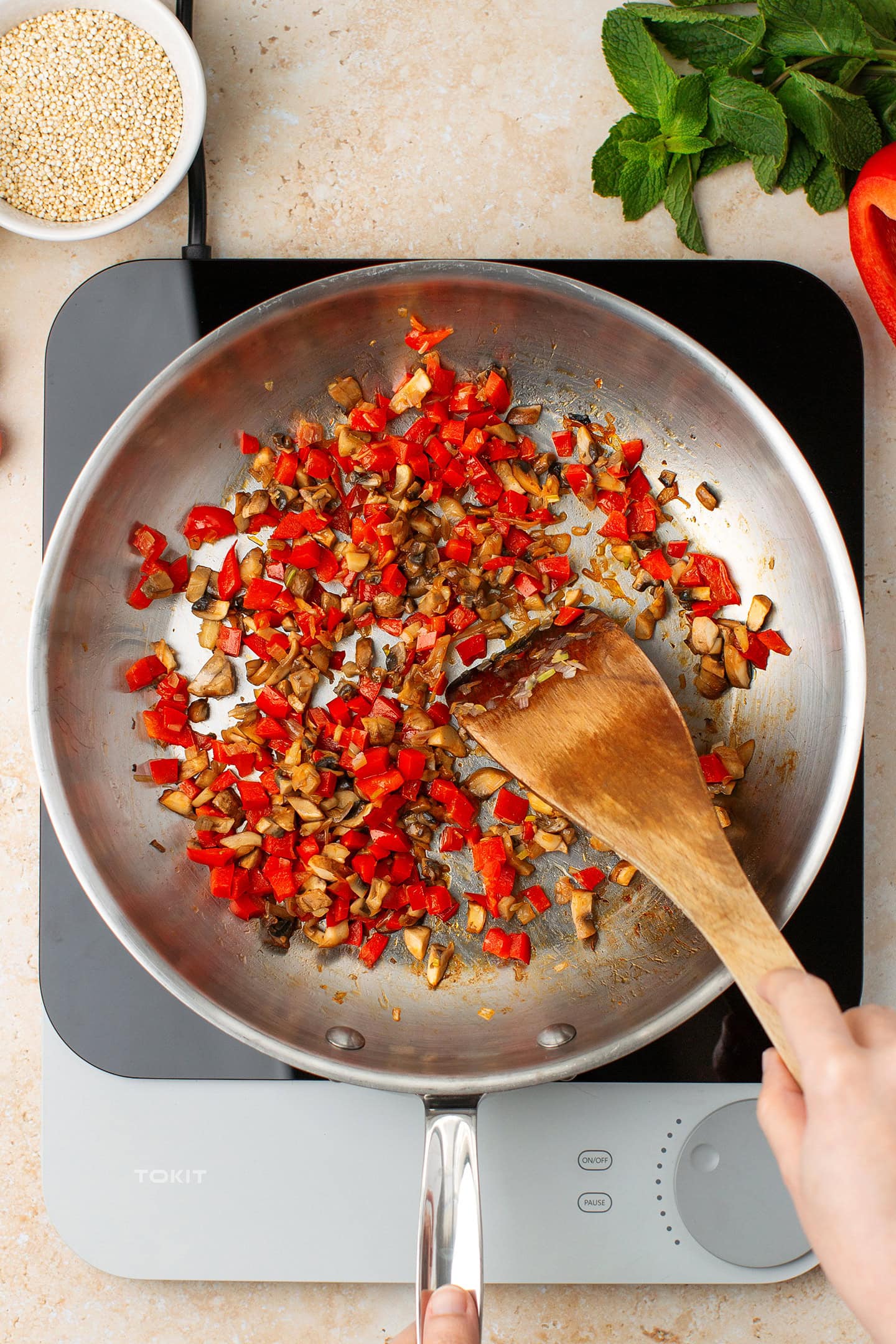 Saut&eacute;ed diced bell peppers and mushrooms in a skillet.