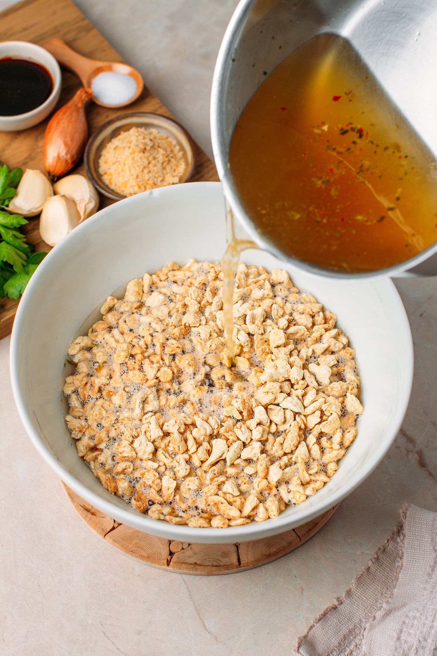 Pouring hot vegetable broth over textured vegetable protein.