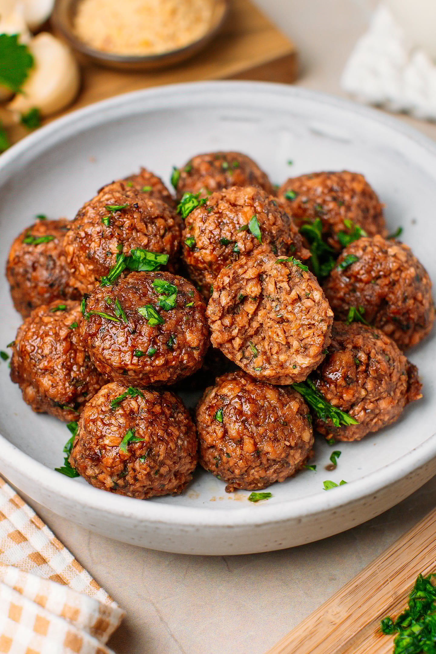 Vegan TVP meatballs topped with chopped parsley in a white plate.
