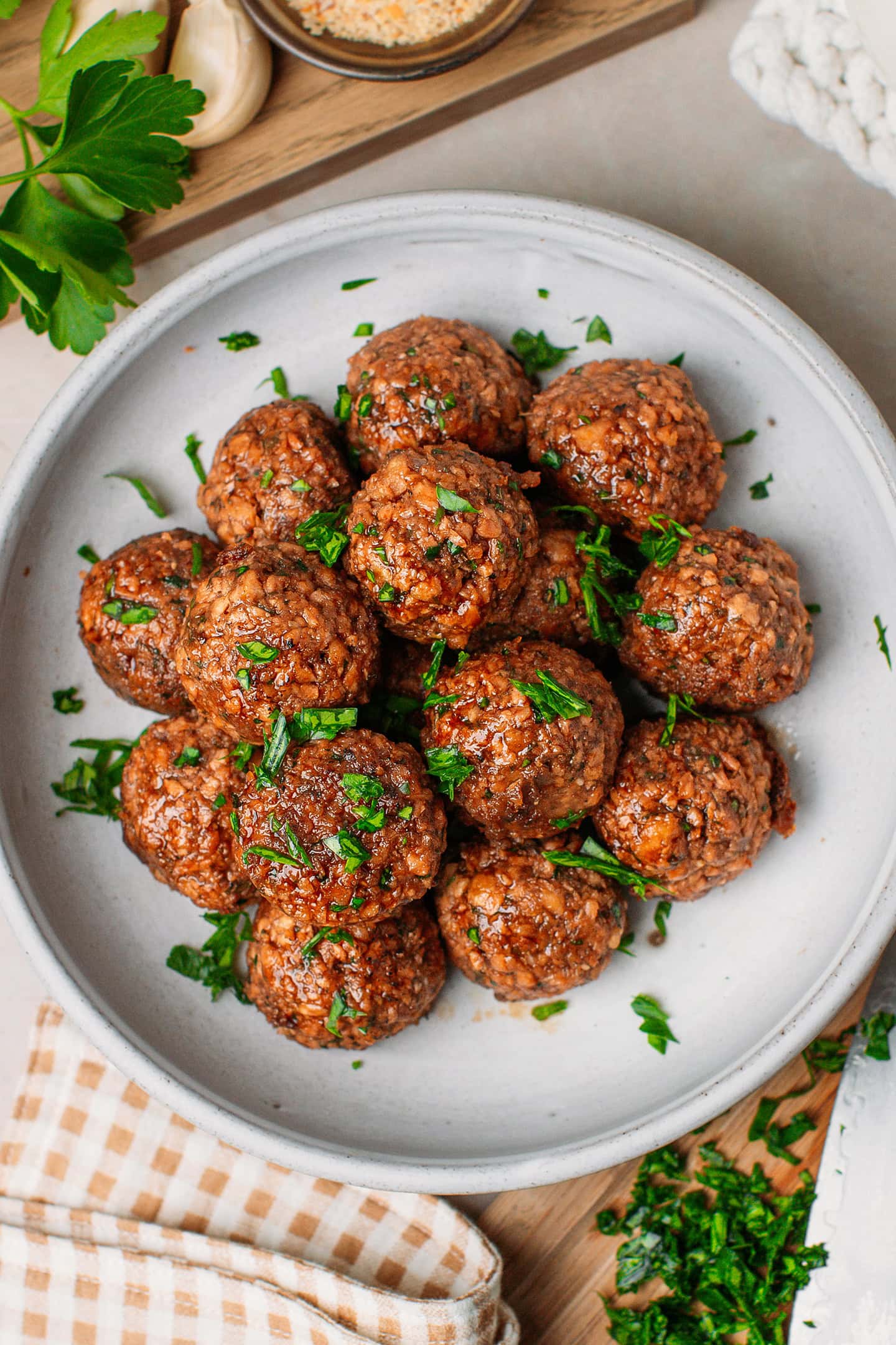Vegan meatballs with chopped parsley in a deep plate.