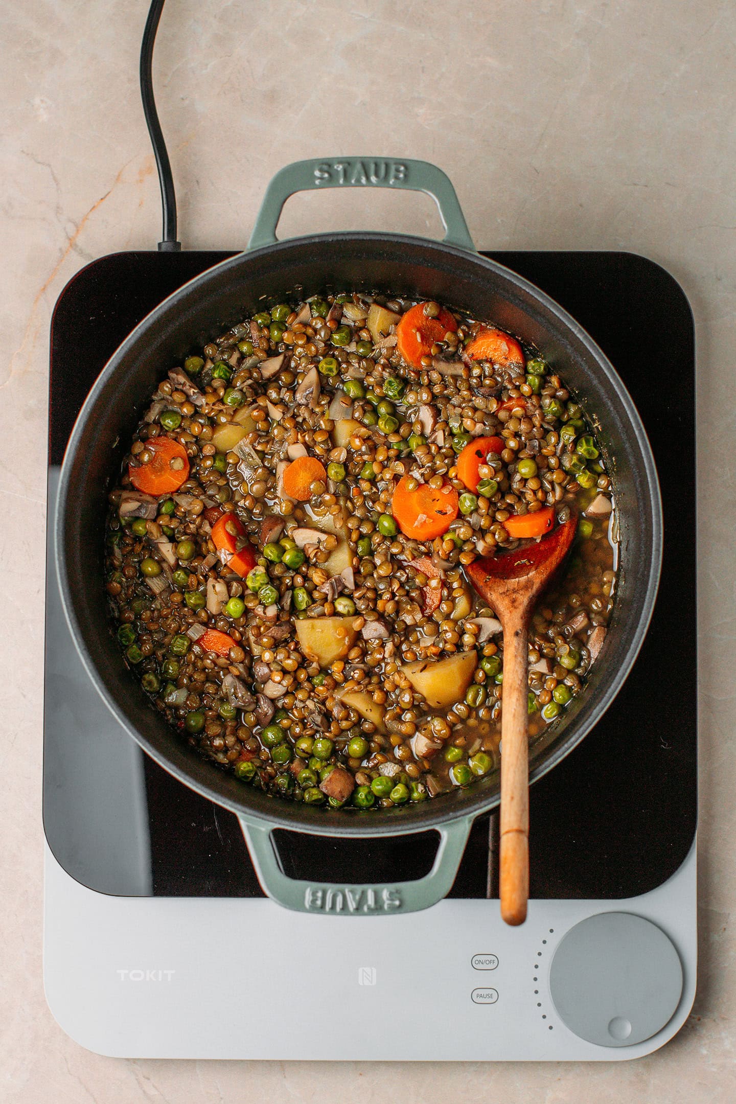 Cooked green lentil stew in a deep pot.