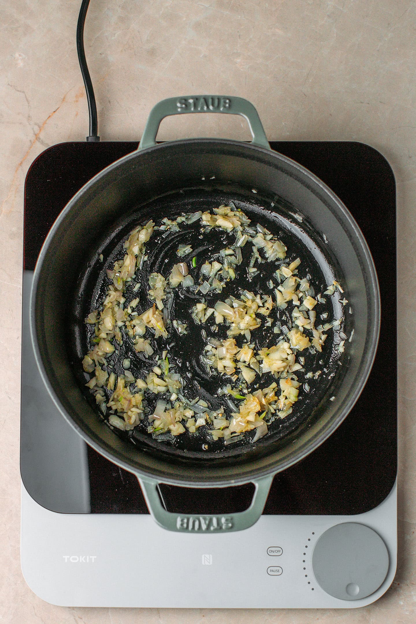 Sautéed shallot and garlic in a pot.