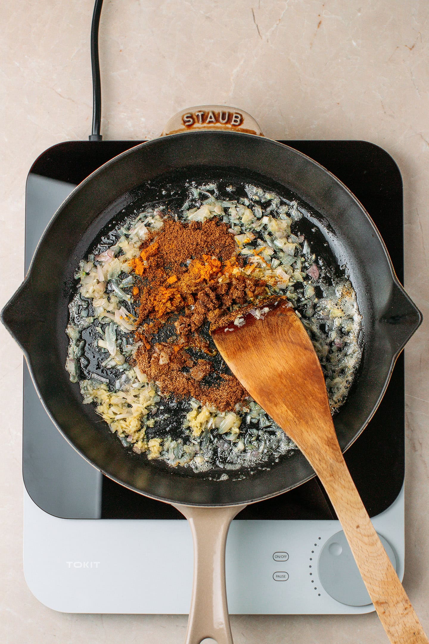 Saut&eacute;ed garlic, shallot, ginger, and spices in a skillet.