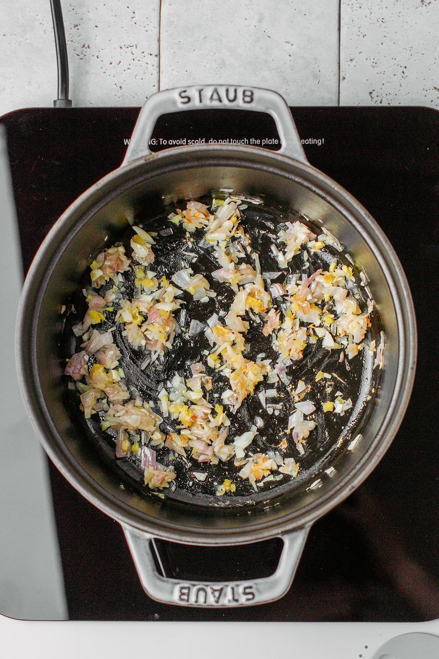 Saut&eacute;ed ginger, garlic, and shallot in a pot.