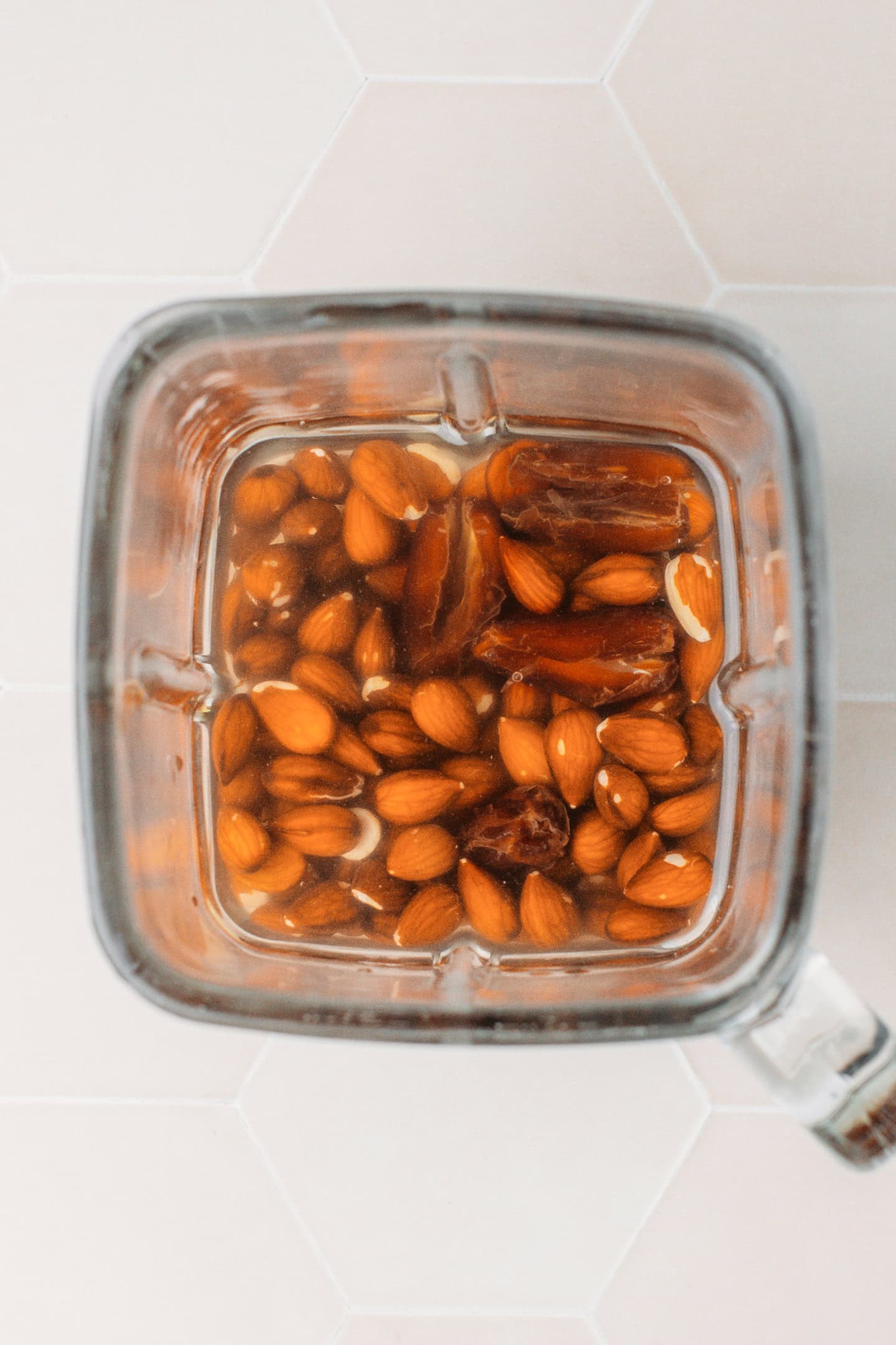 Raw almonds, dates, and vanilla extract in a blender.