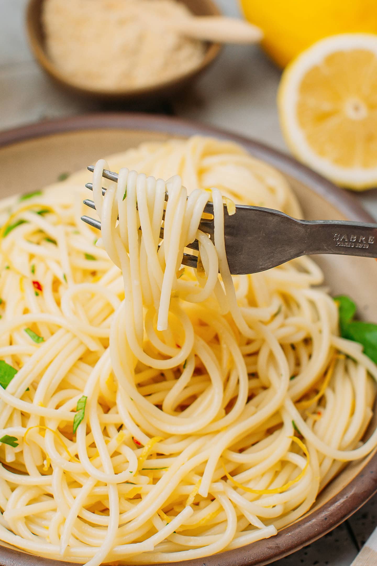 Close-up of a fork holding lemon pasta.