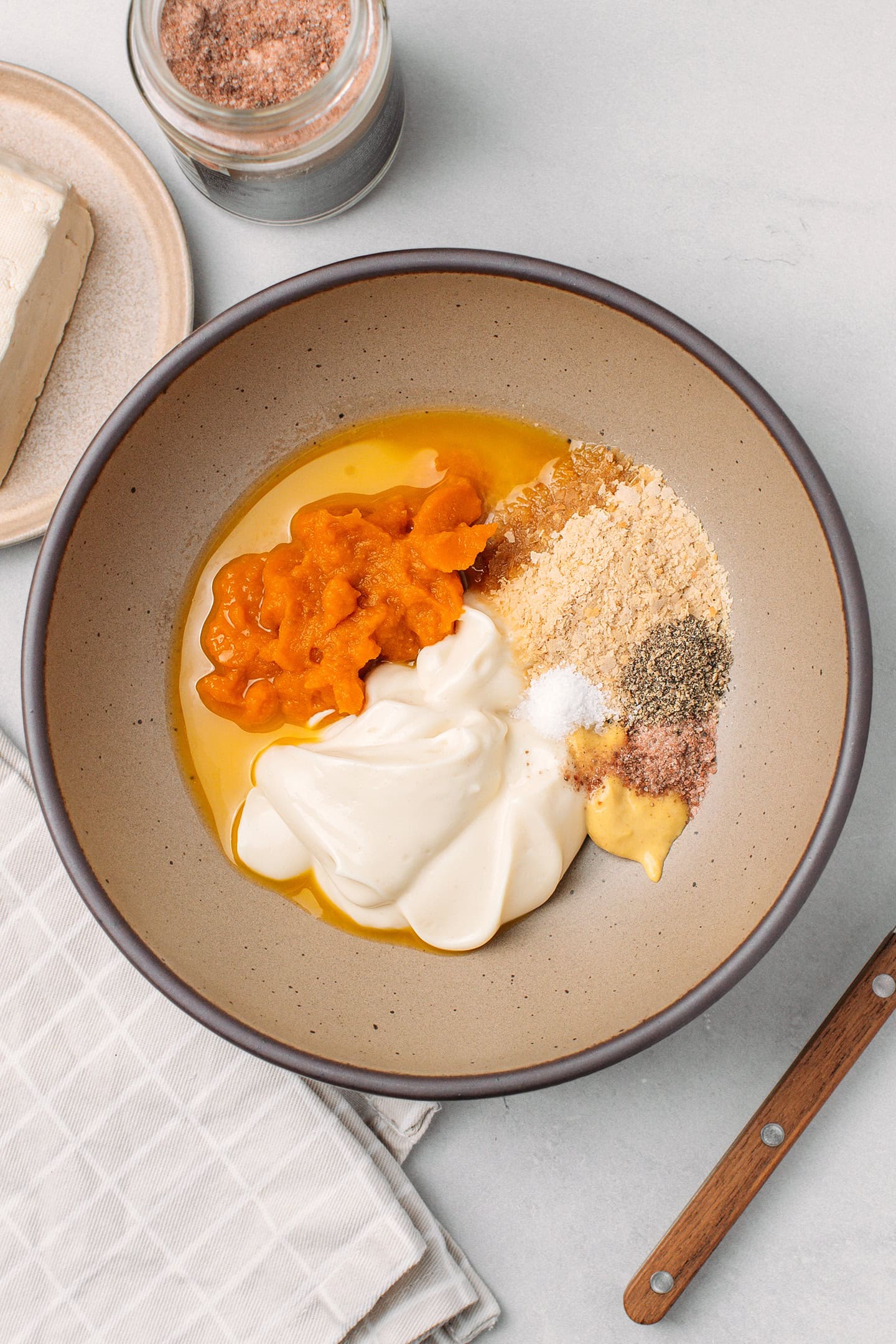 Pumpkin purée, mayo, salt, kala namak, nutritional yeast, and mustard in mixing bowl.