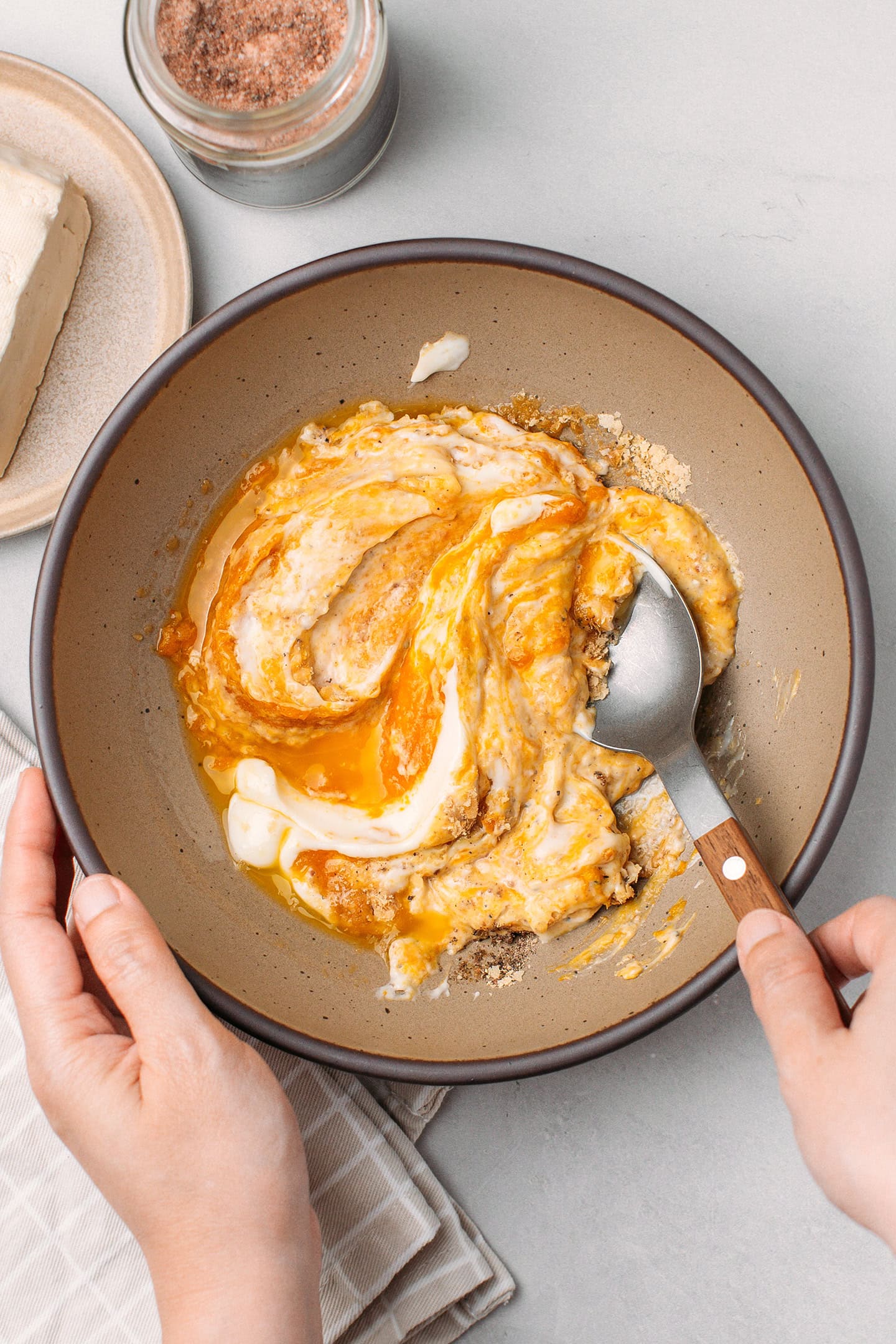 Mixing pumpkin purée with mayo, salt, and pepper, in a bowl.