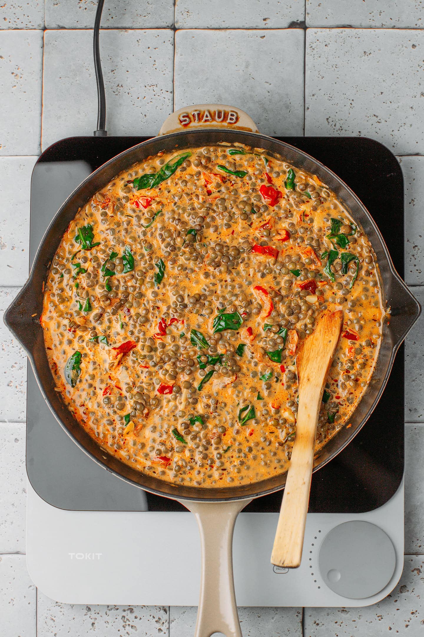 Green lentils and spinach in a Tuscan sauce in a skillet.
