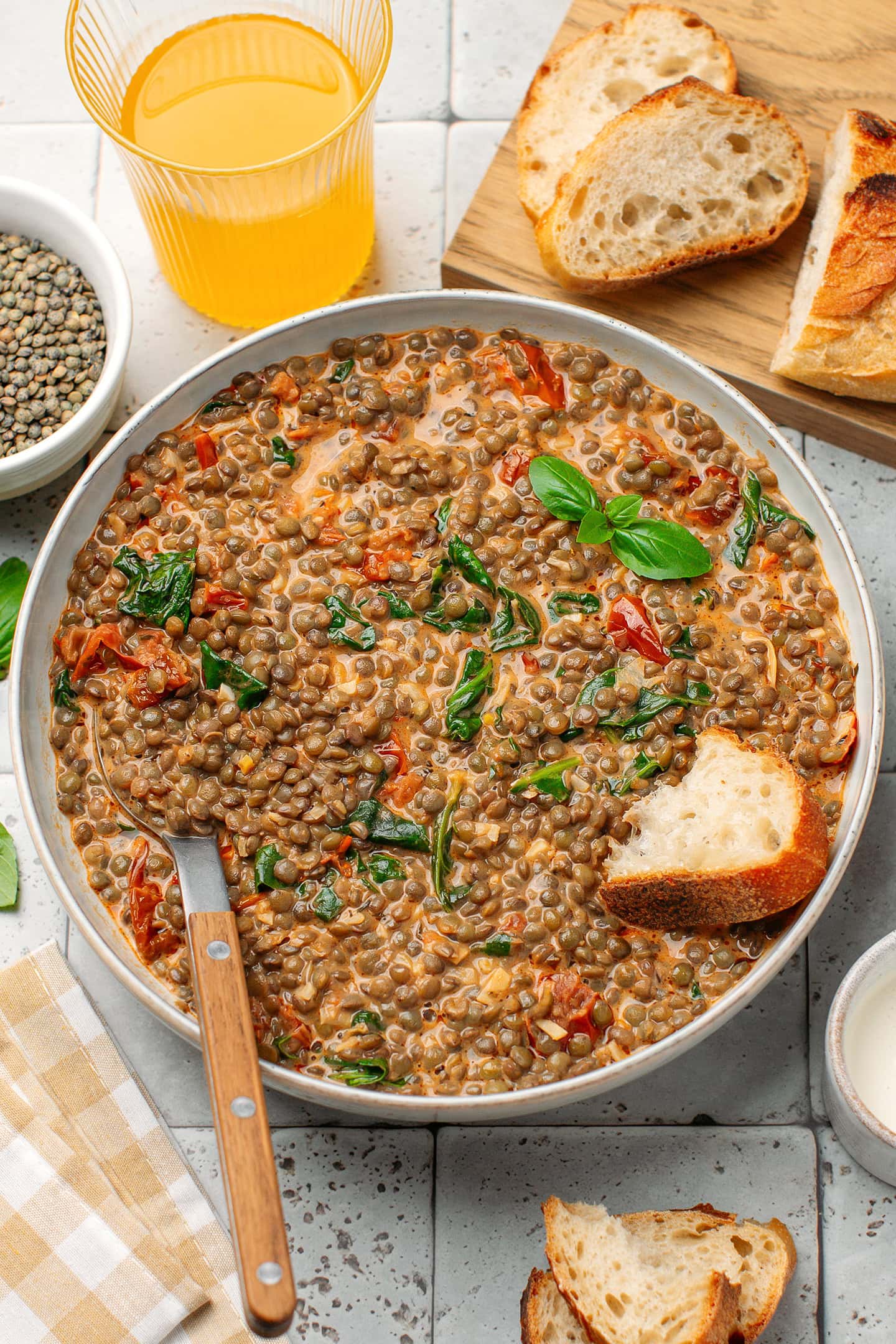 Bowl of green lentils in a tomato and garlic sauce.