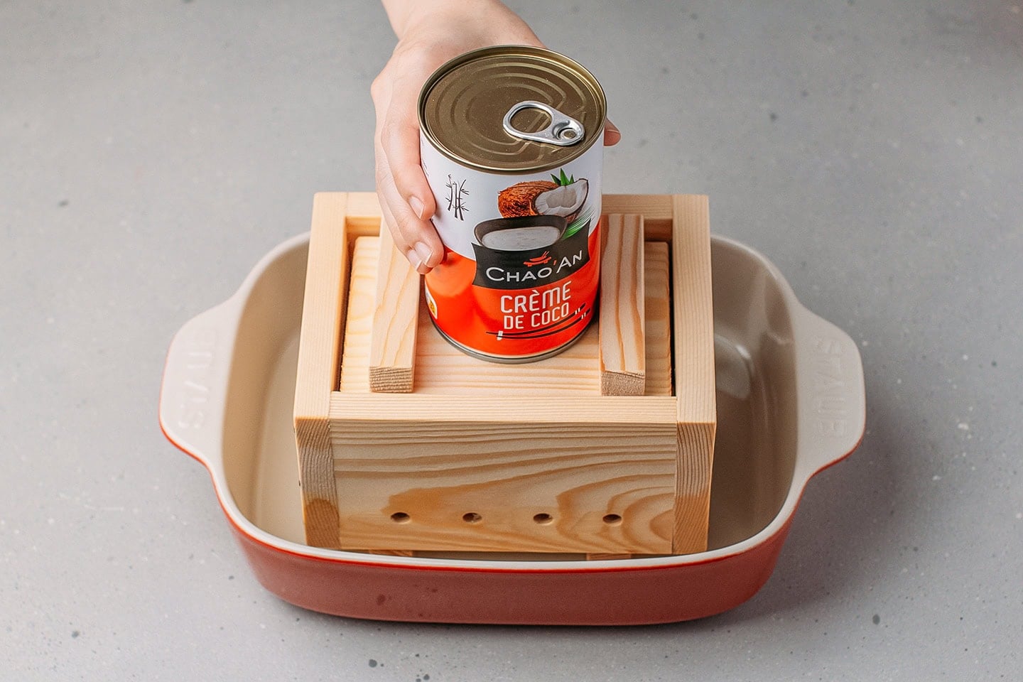 Placing cans of coconut cream over the tofu press.