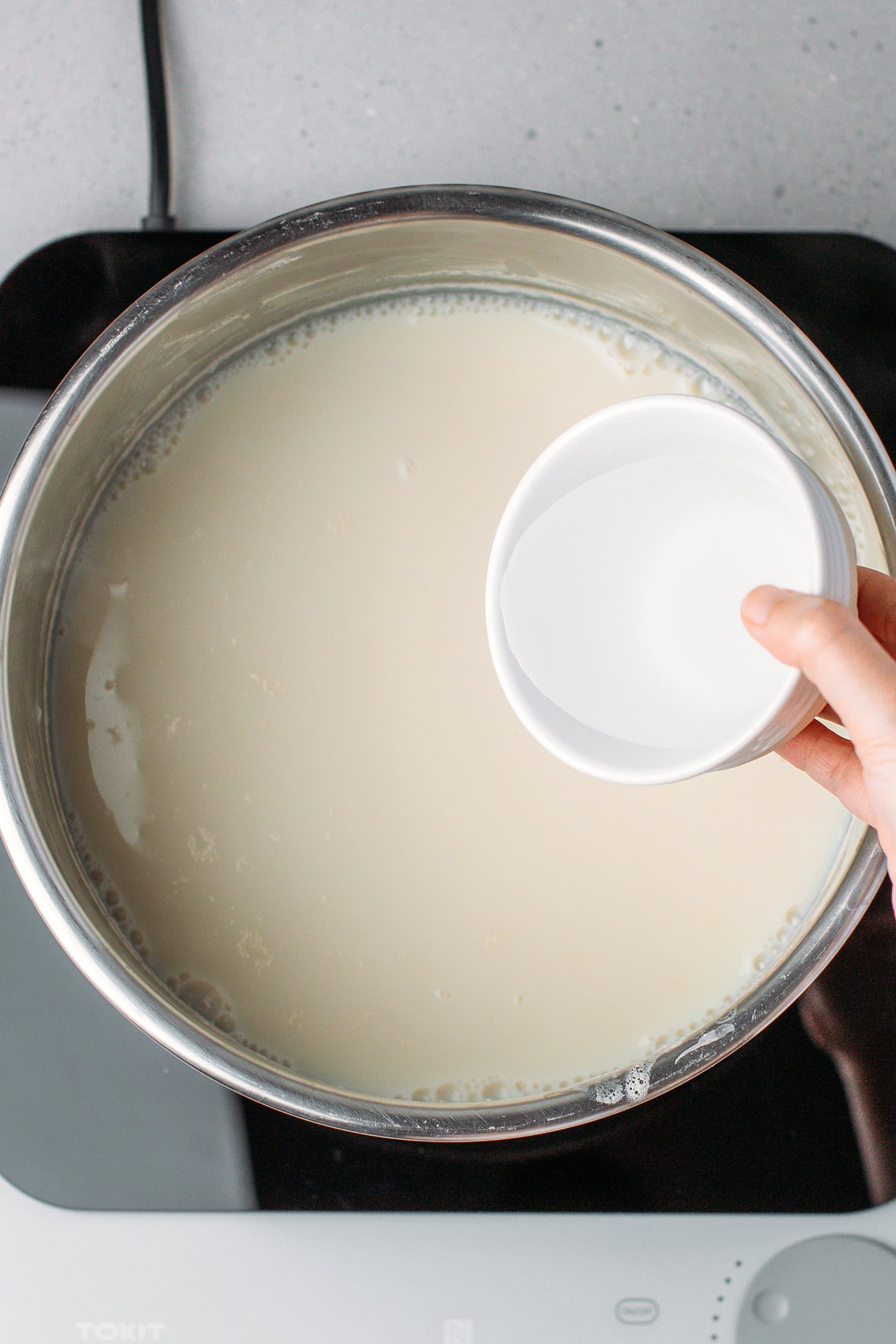 Pouring dissolved nigari into fava bean milk.