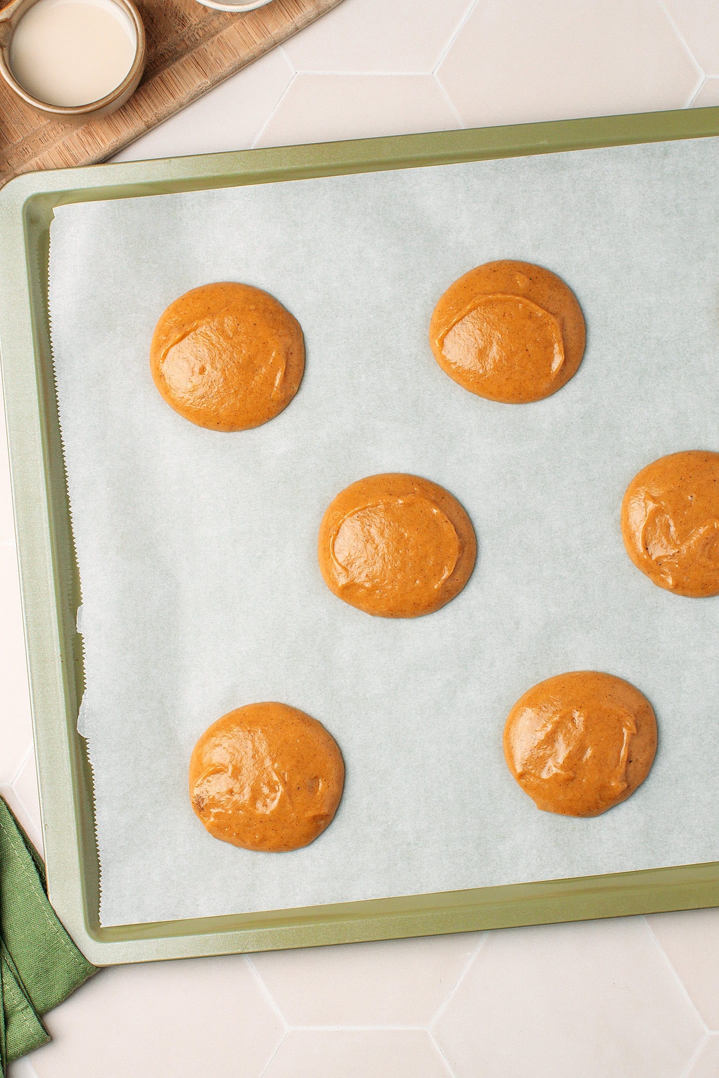 Unbaked pumpkin cakes on a baking sheet.