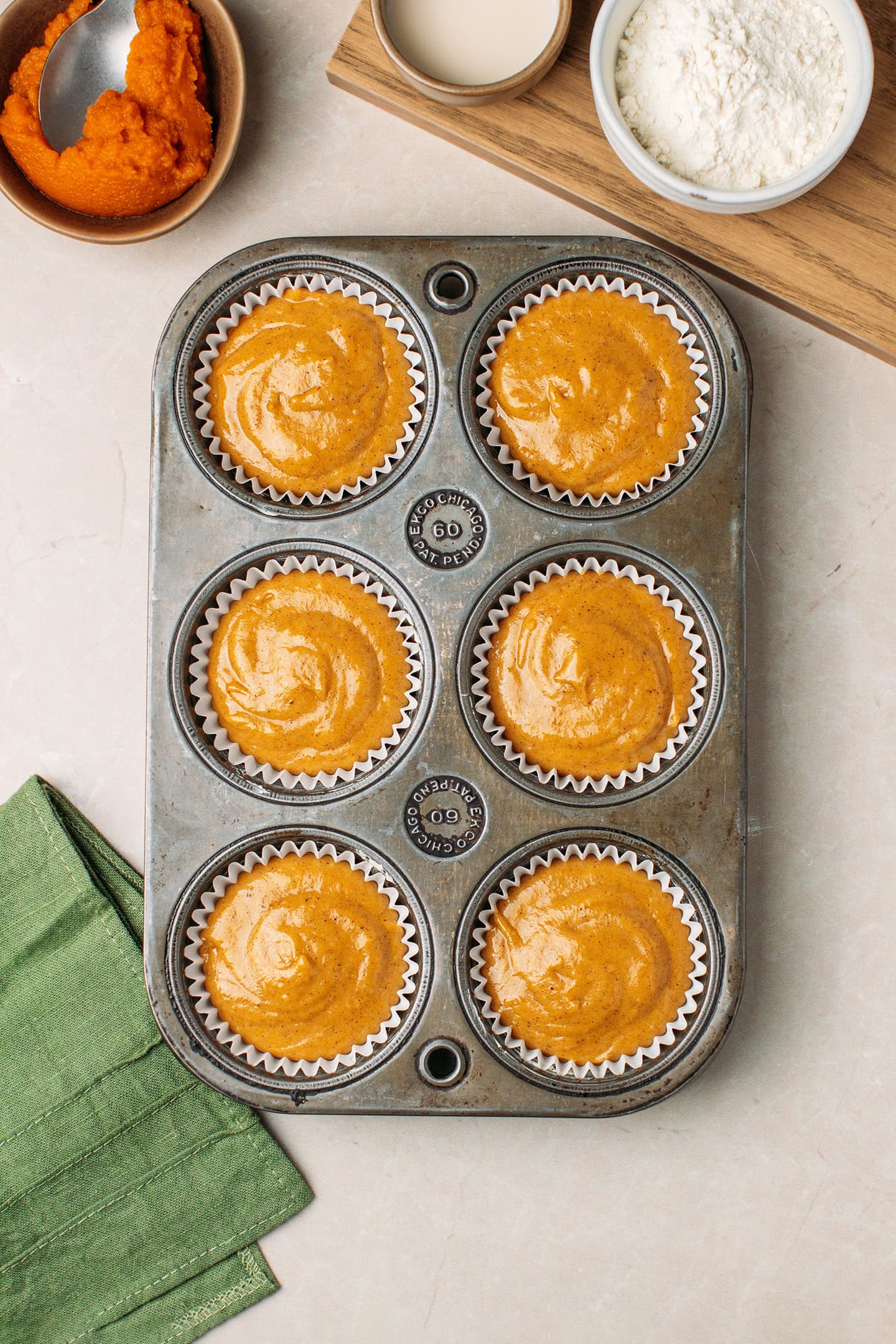 Muffin pan filled with pumpkin batter.