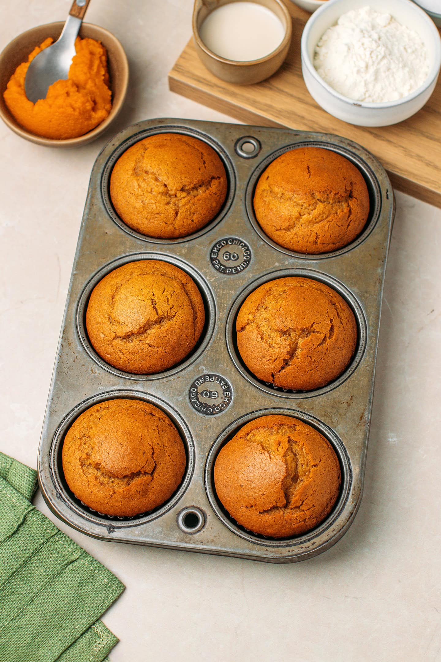 Six baked muffins in a pan.